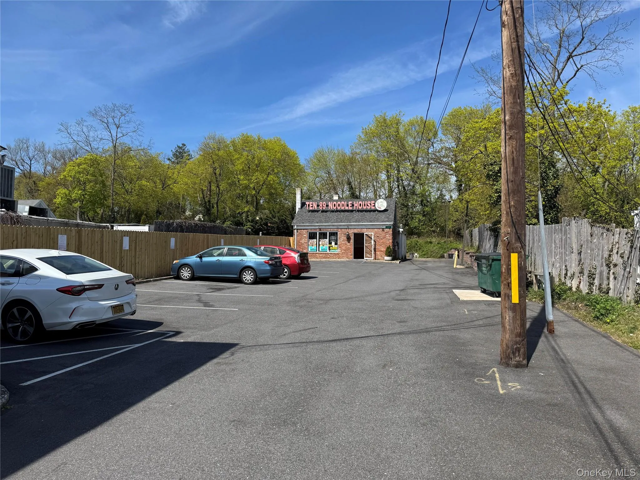Uncovered parking lot featuring fence Uncovered parking lot featuring fence