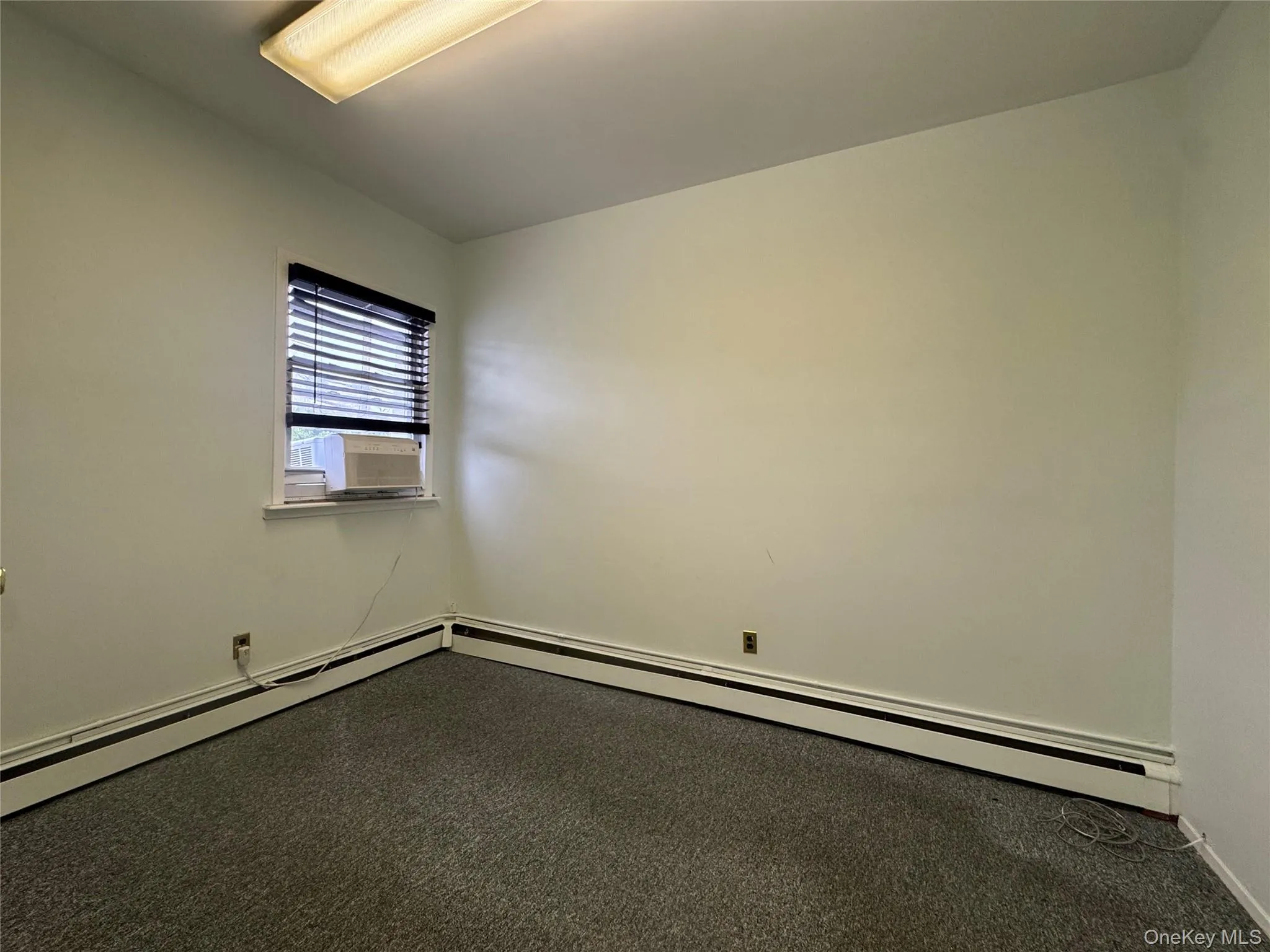 Unfurnished room featuring cooling unit and baseboards Unfurnished room featuring cooling unit and baseboards