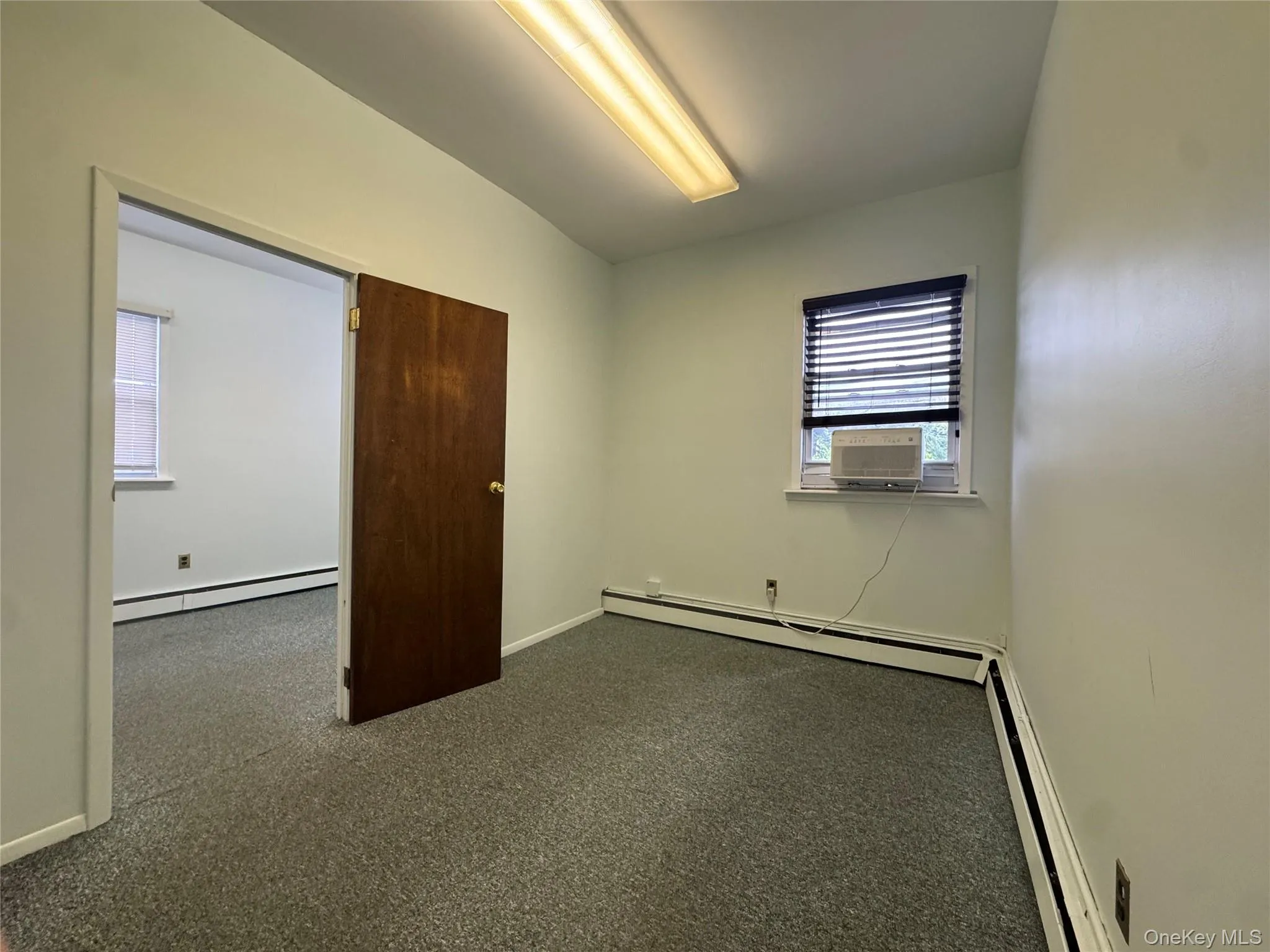 Unfurnished bedroom featuring a baseboard heating unit, baseboards, and a baseboard radiator Unfurnished bedroom featuring a baseboard heating unit, baseboards, and a baseboard radiator