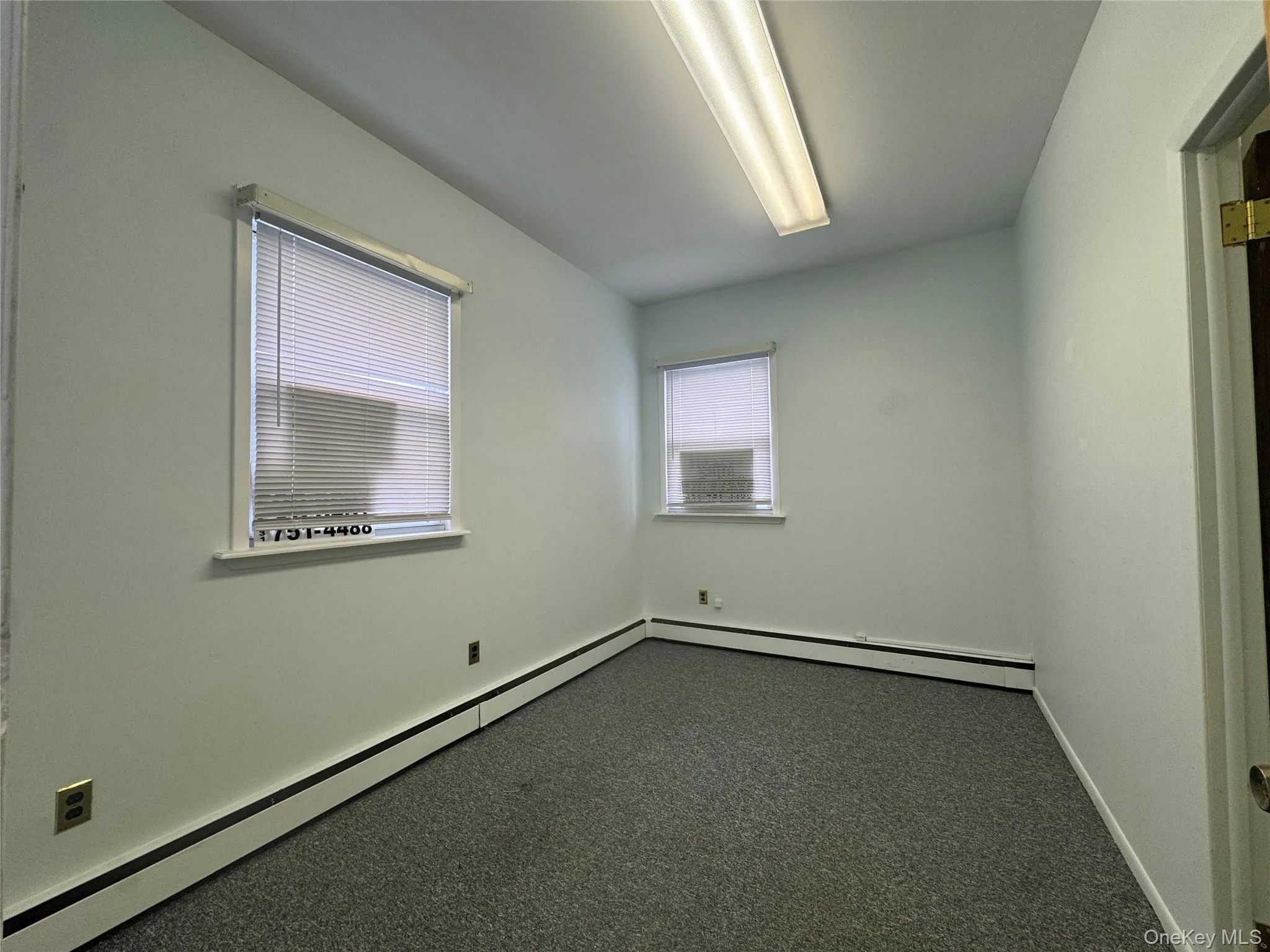 Spare room featuring dark colored carpet and baseboards Spare room featuring dark colored carpet and baseboards