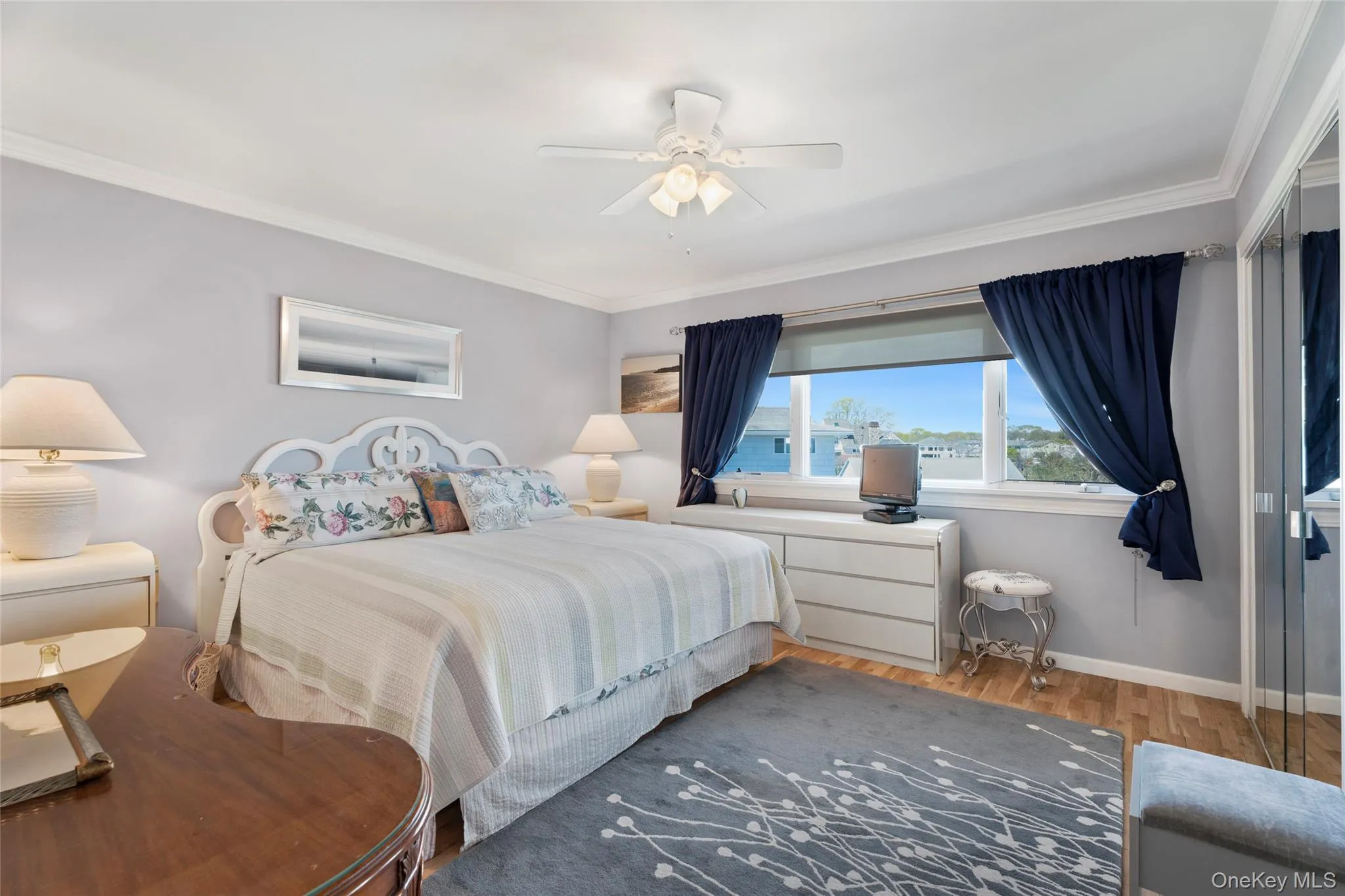Bedroom featuring wood finished floors, crown molding, baseboards, and a ceiling fan Bedroom featuring wood finished floors, crown molding, baseboards, and a ceiling fan
