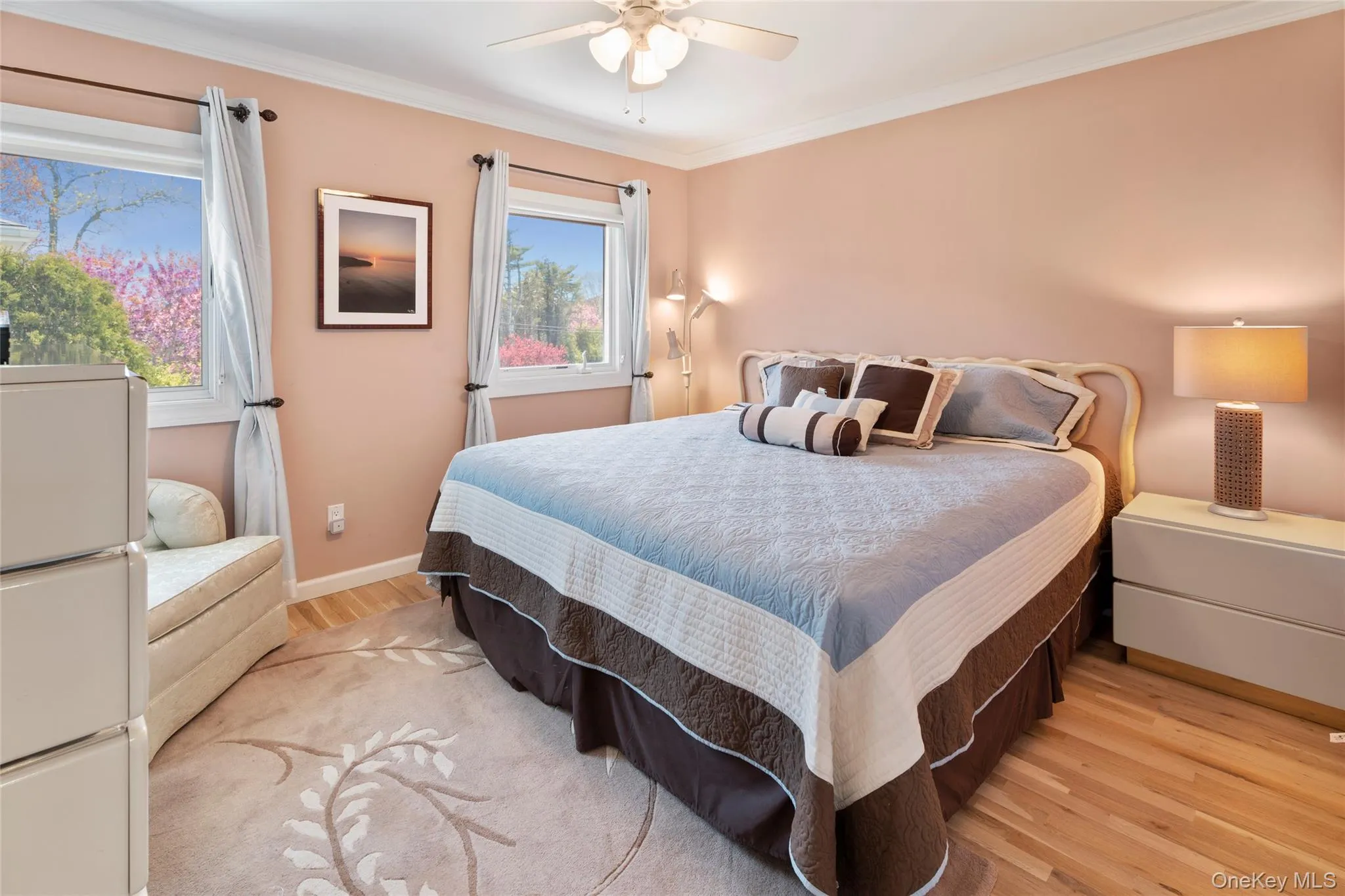 Bedroom with baseboards, light wood-style flooring, freestanding refrigerator, and crown molding Bedroom with baseboards, light wood-style flooring, freestanding refrigerator, and crown molding