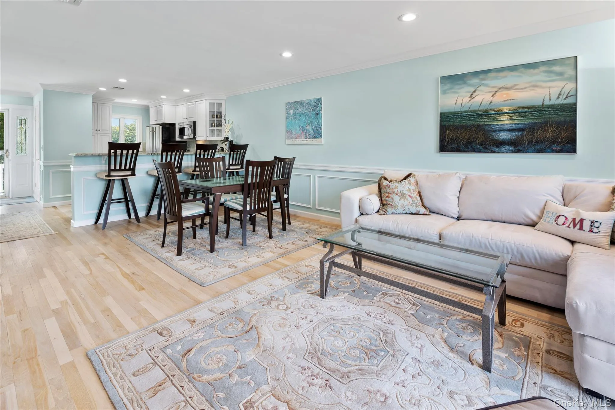 Living area with recessed lighting, a decorative wall, crown molding, and light wood-type flooring Living area with recessed lighting, a decorative wall, crown molding, and light wood-type flooring