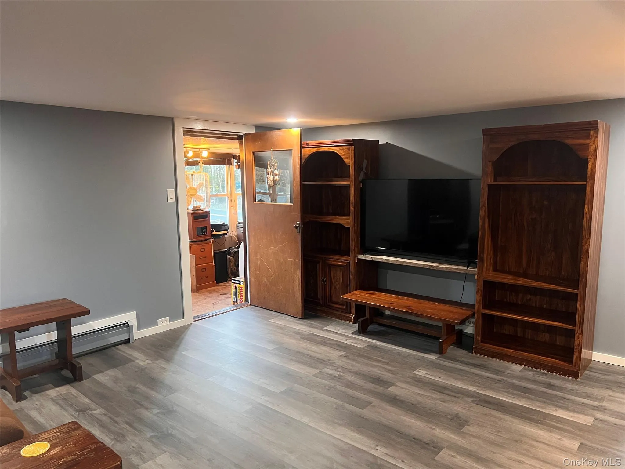 Living room with wood finished floors and a baseboard radiator Living room with wood finished floors and a baseboard radiator
