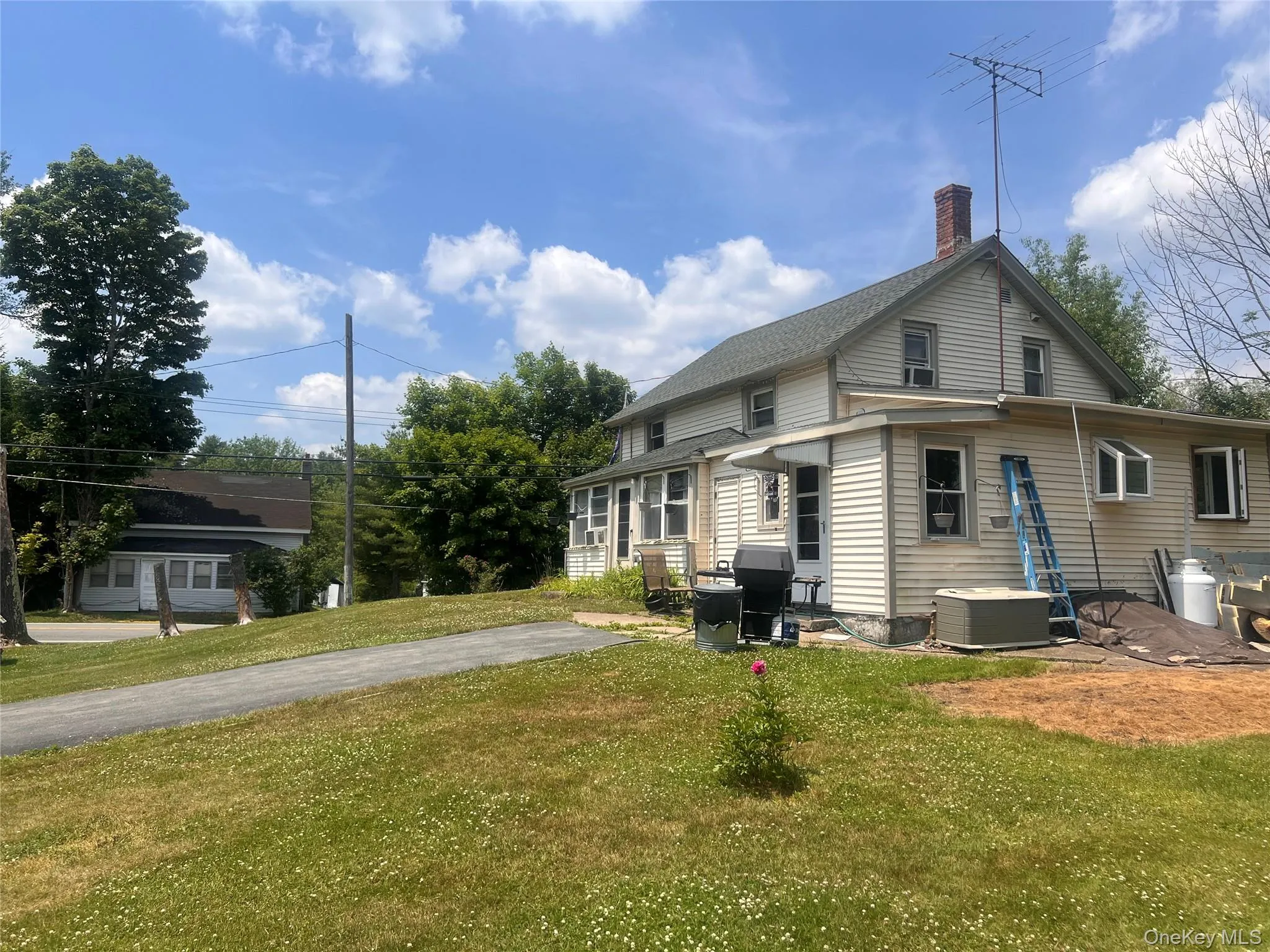 Rear view of house with a lawn, a chimney, and a patio Rear view of house with a lawn, a chimney, and a patio