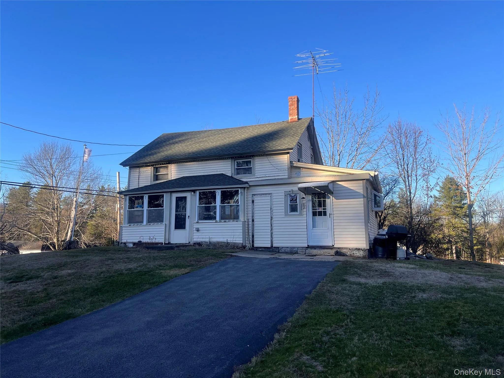 View of front of home with a chimney, a front lawn, and driveway View of front of home with a chimney, a front lawn, and driveway