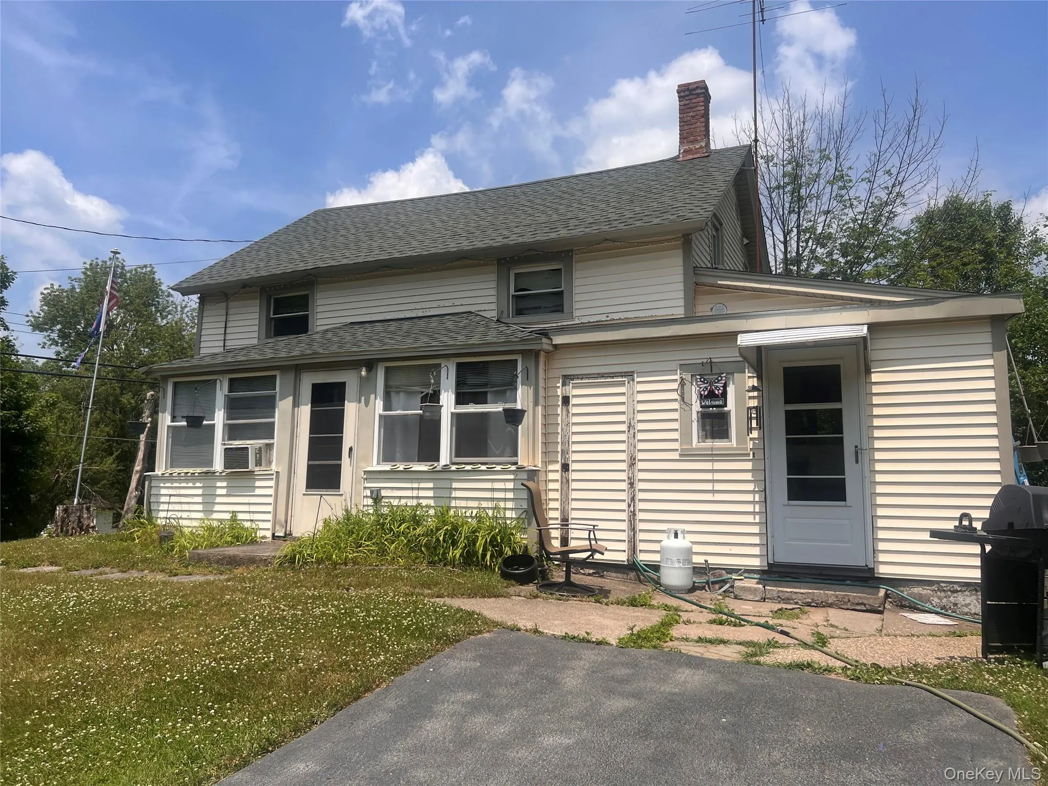Back of property with a chimney, a shingled roof, and a yard Back of property with a chimney, a shingled roof, and a yard