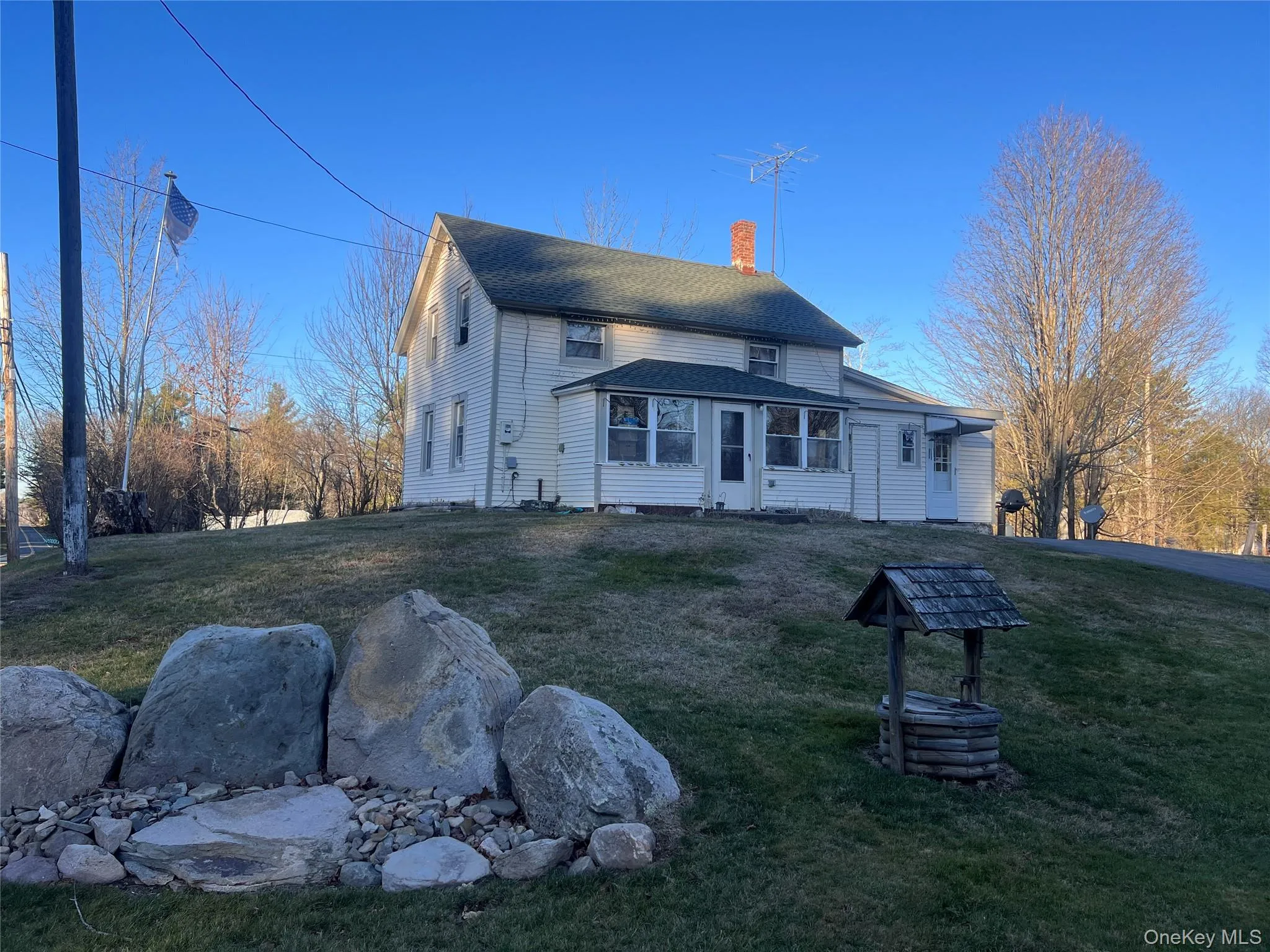 Rear view of house with a lawn, a chimney, and a shingled roof Rear view of house with a lawn, a chimney, and a shingled roof