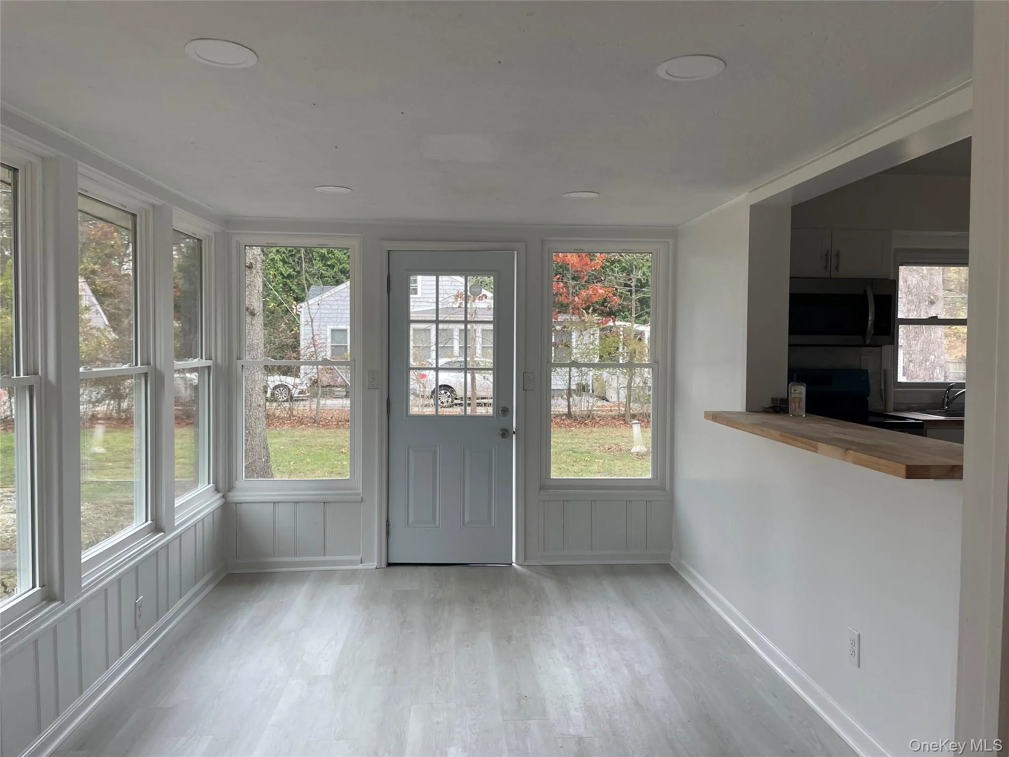 Unfurnished sunroom featuring wood finished floors and baseboards Unfurnished sunroom featuring wood finished floors and baseboards