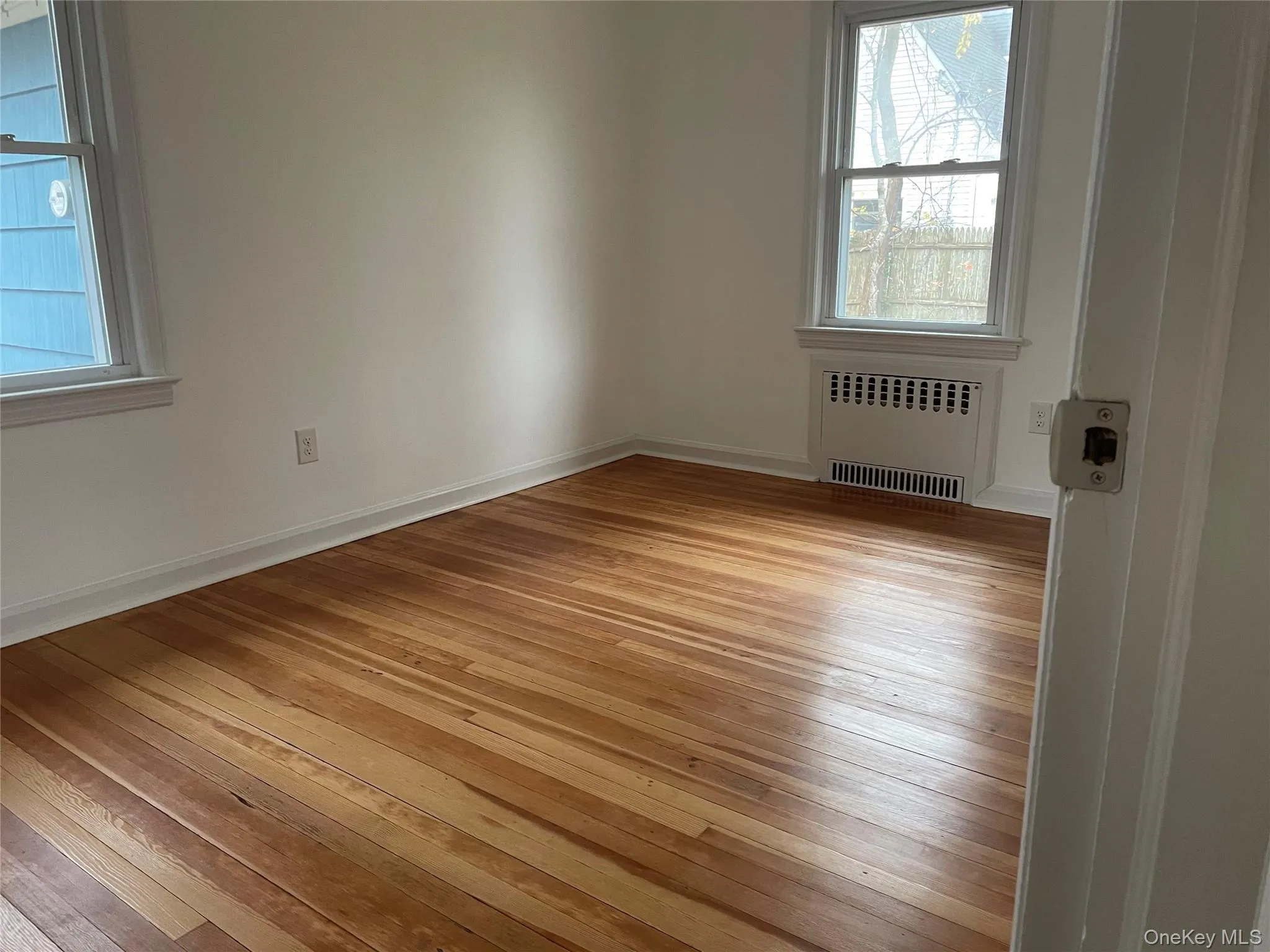 Empty room featuring radiator heating unit and light wood-style flooring Empty room featuring radiator heating unit and light wood-style flooring