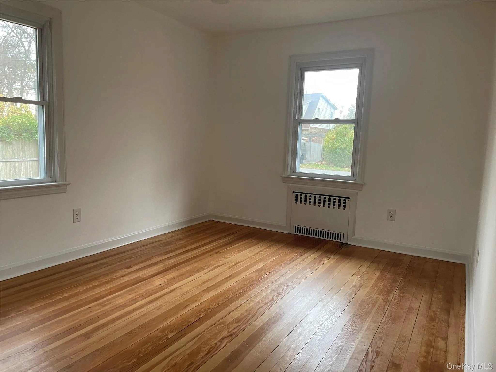 Spare room with radiator heating unit and light wood-style floors Spare room with radiator heating unit and light wood-style floors