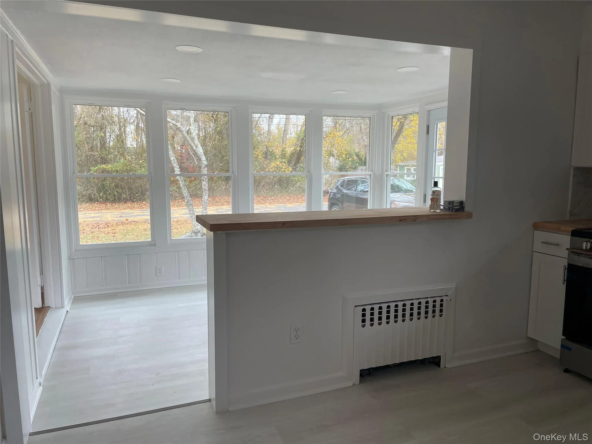 Unfurnished dining area featuring radiator heating unit, plenty of natural light, and light wood finished floors Unfurnished dining area featuring radiator heating unit, plenty of natural light, and light wood finished floors