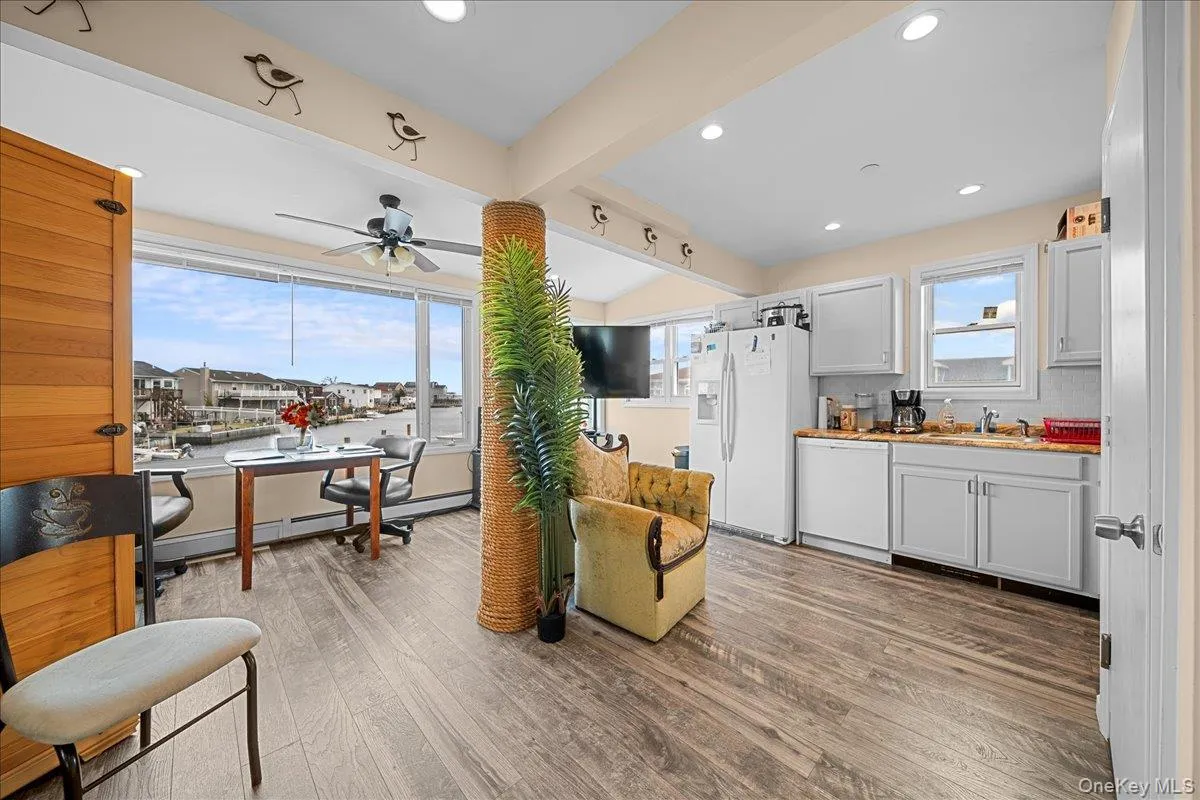 Living area featuring recessed lighting, a ceiling fan, beam ceiling, and light wood-style floors Living area featuring recessed lighting, a ceiling fan, beam ceiling, and light wood-style floors