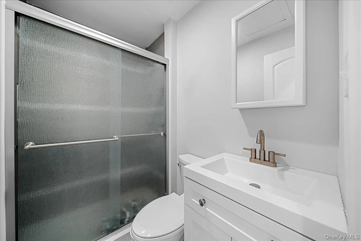 Full bath featuring vanity, a shower stall, and toilet Full bath featuring vanity, a shower stall, and toilet