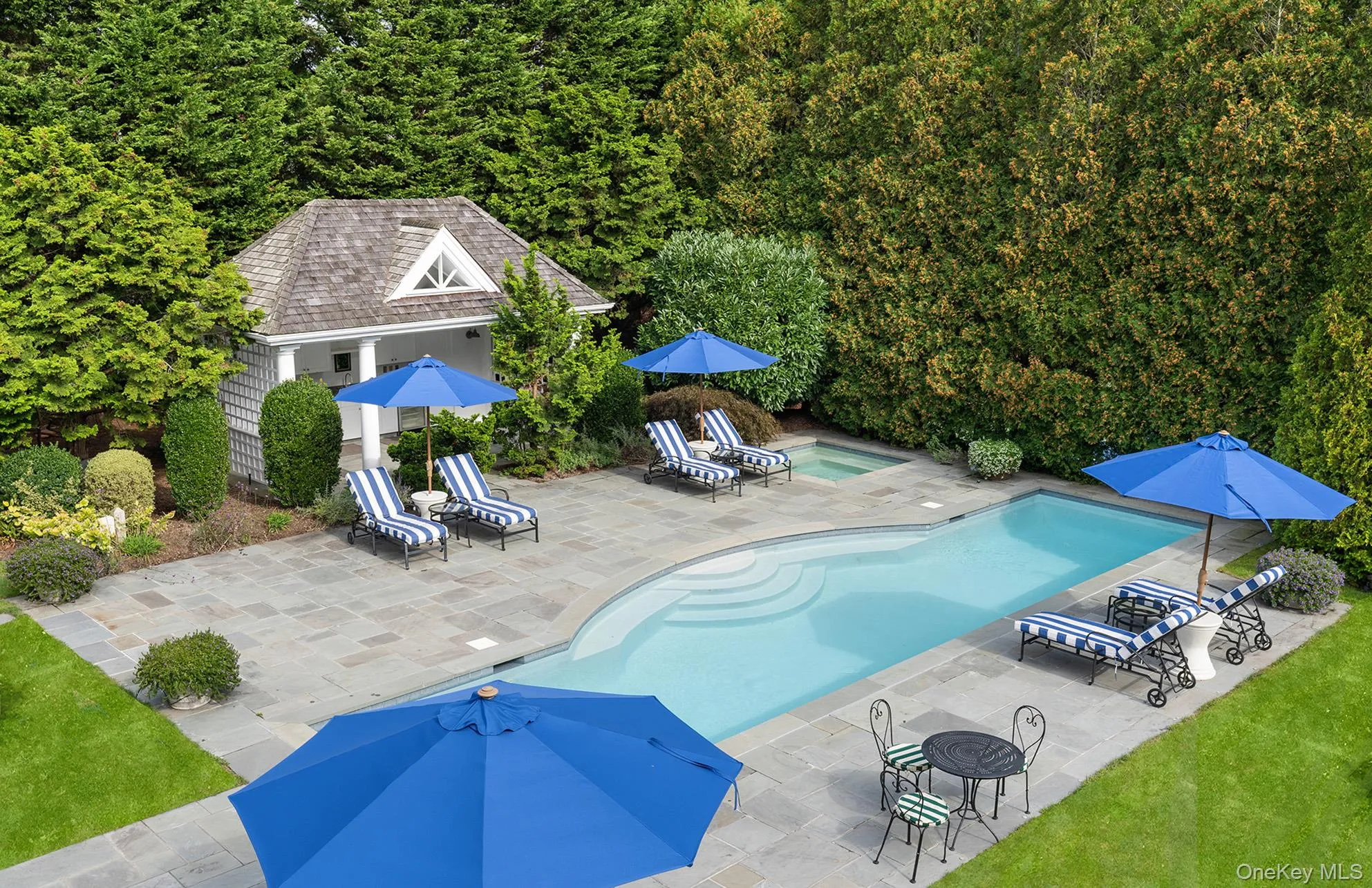 Outdoor pool with an outdoor structure and a patio area Outdoor pool with an outdoor structure and a patio area