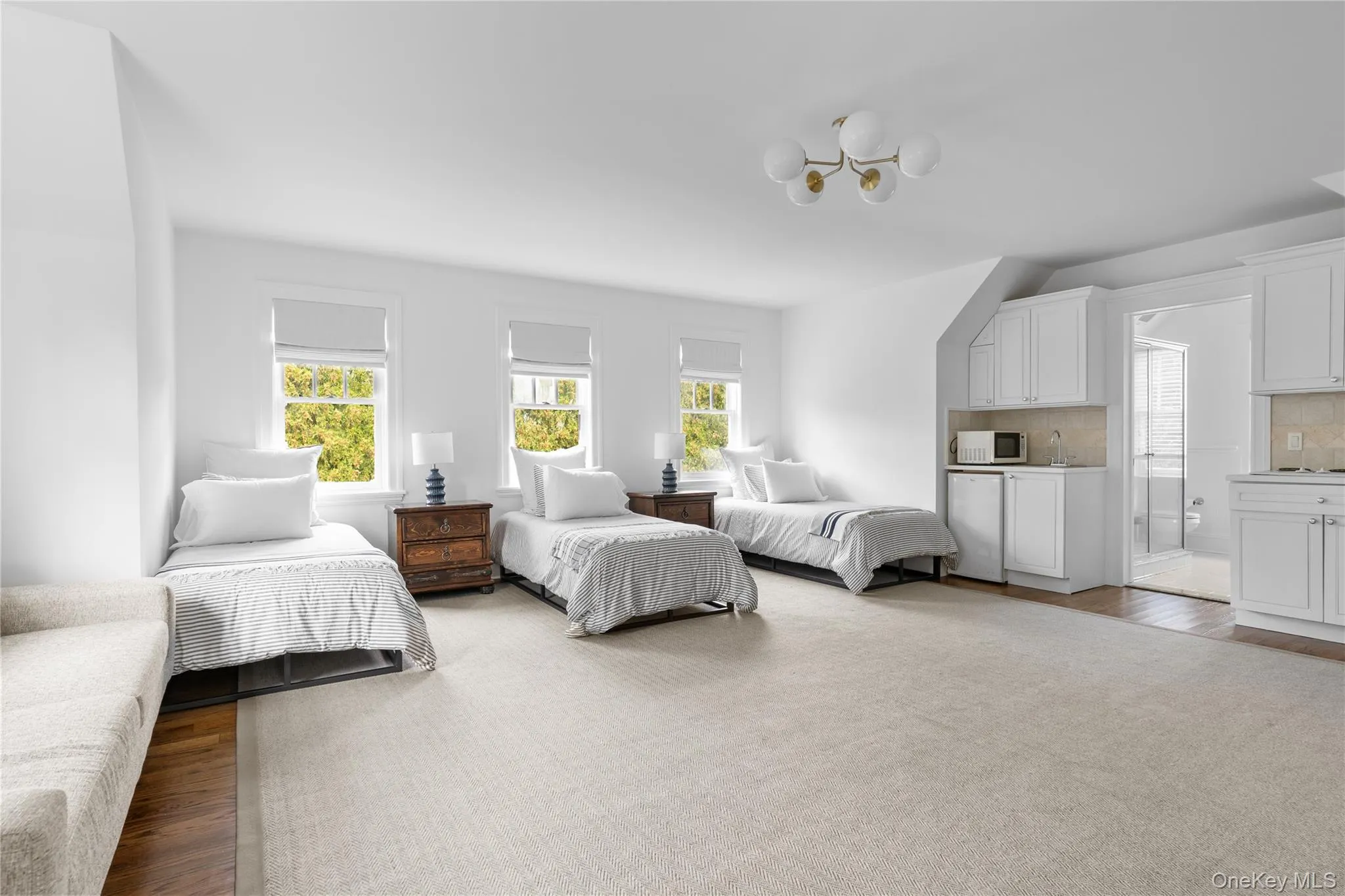 Bedroom with wood finished floors, fridge, and a notable chandelier Bedroom with wood finished floors, fridge, and a notable chandelier