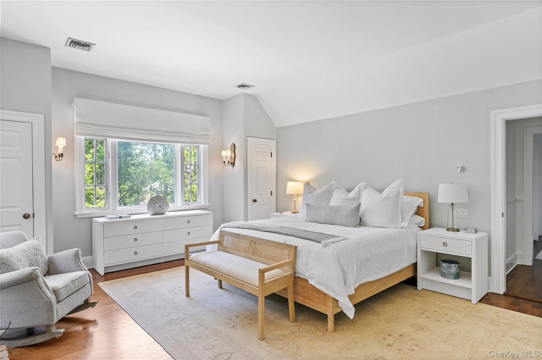 Bedroom with vaulted ceiling, light wood finished floors, and visible vents Bedroom with vaulted ceiling, light wood finished floors, and visible vents