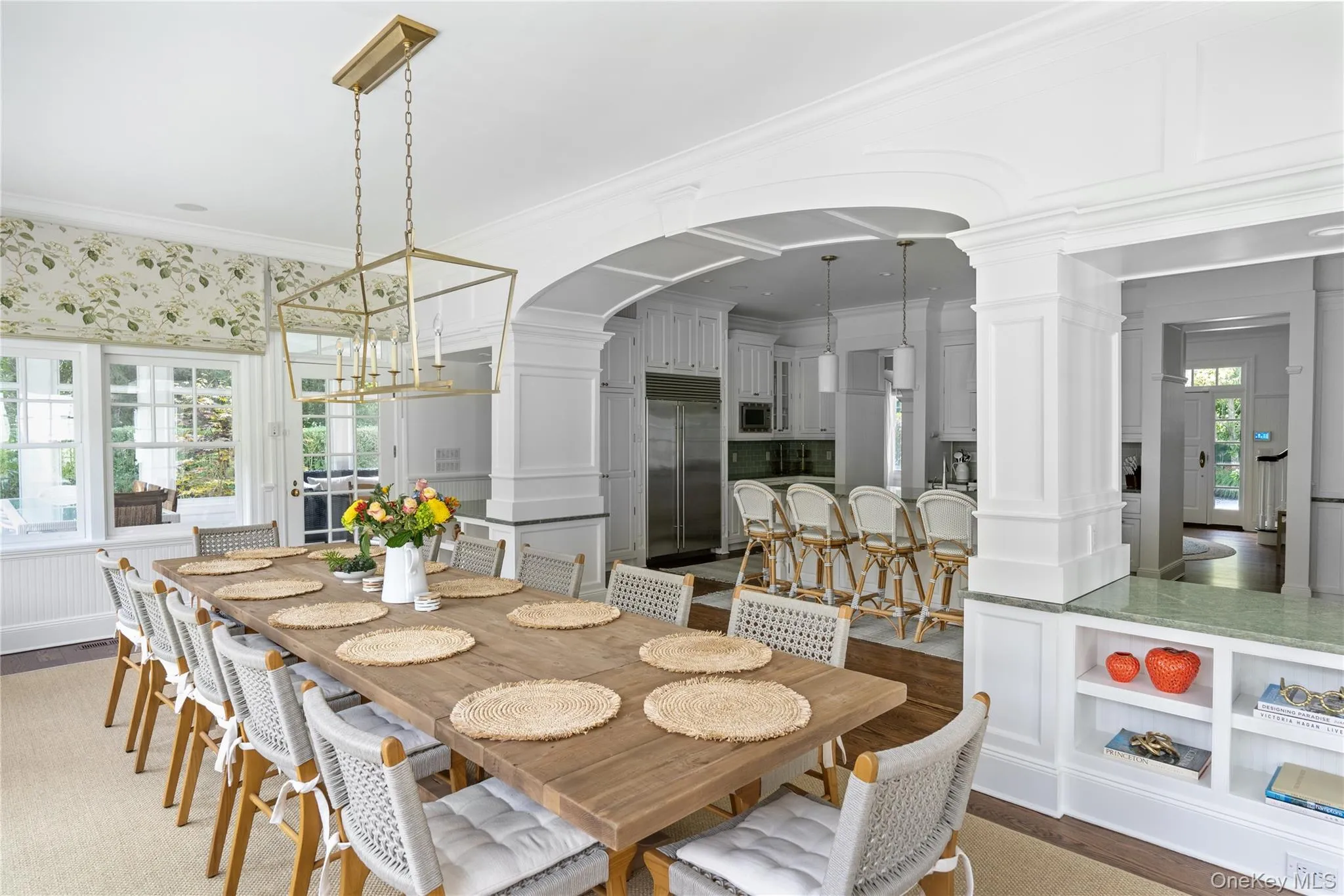 Dining area with arched walkways, a decorative wall, ornate columns, and crown molding Dining area with arched walkways, a decorative wall, ornate columns, and crown molding
