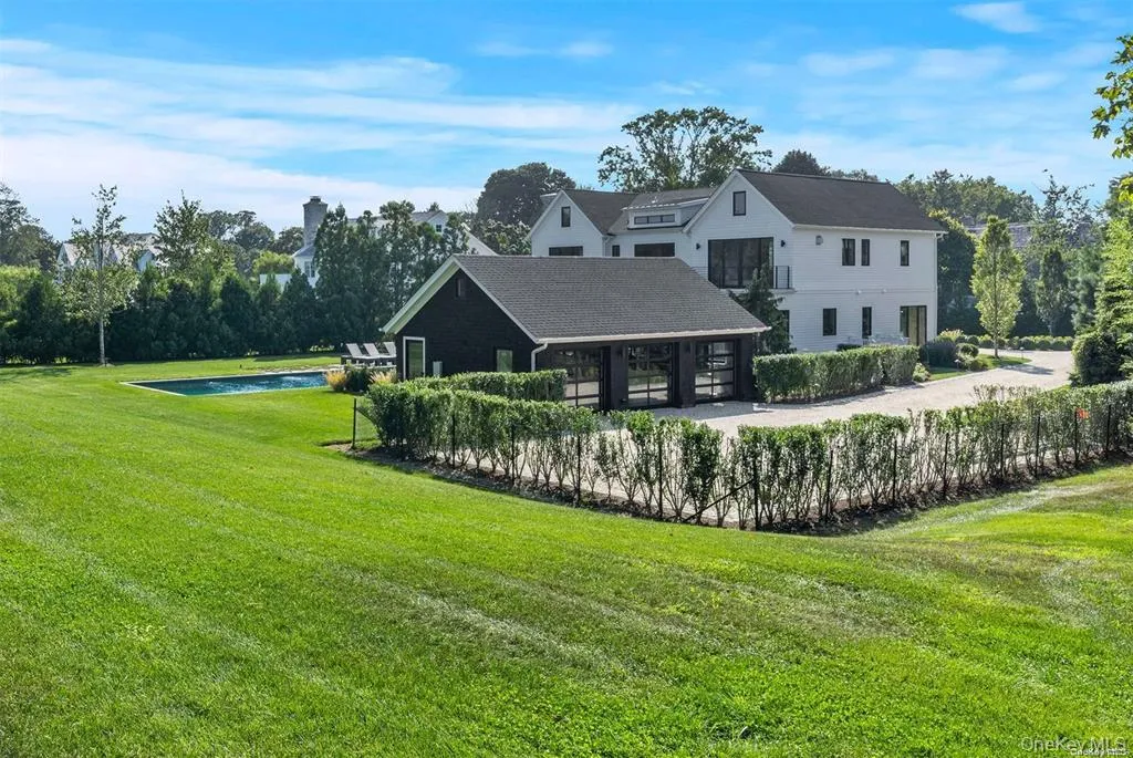 View of yard featuring a detached garage and driveway View of yard featuring a detached garage and driveway