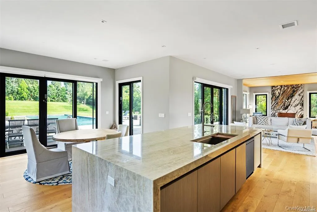 Eat In Kitchen featuring light wood finished floors, a sink, a spacious island, open floor plan, and visible vents Eat In Kitchen featuring light wood finished floors, a sink, a spacious island, open floor plan, and visible vents