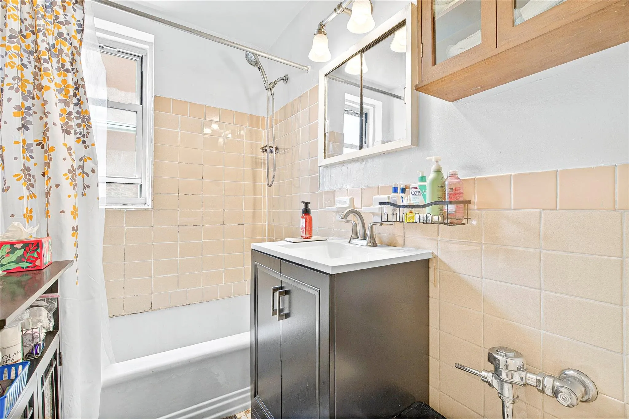 Bathroom with tile walls, shower / bath combo, and vanity Bathroom with tile walls, shower / bath combo, and vanity