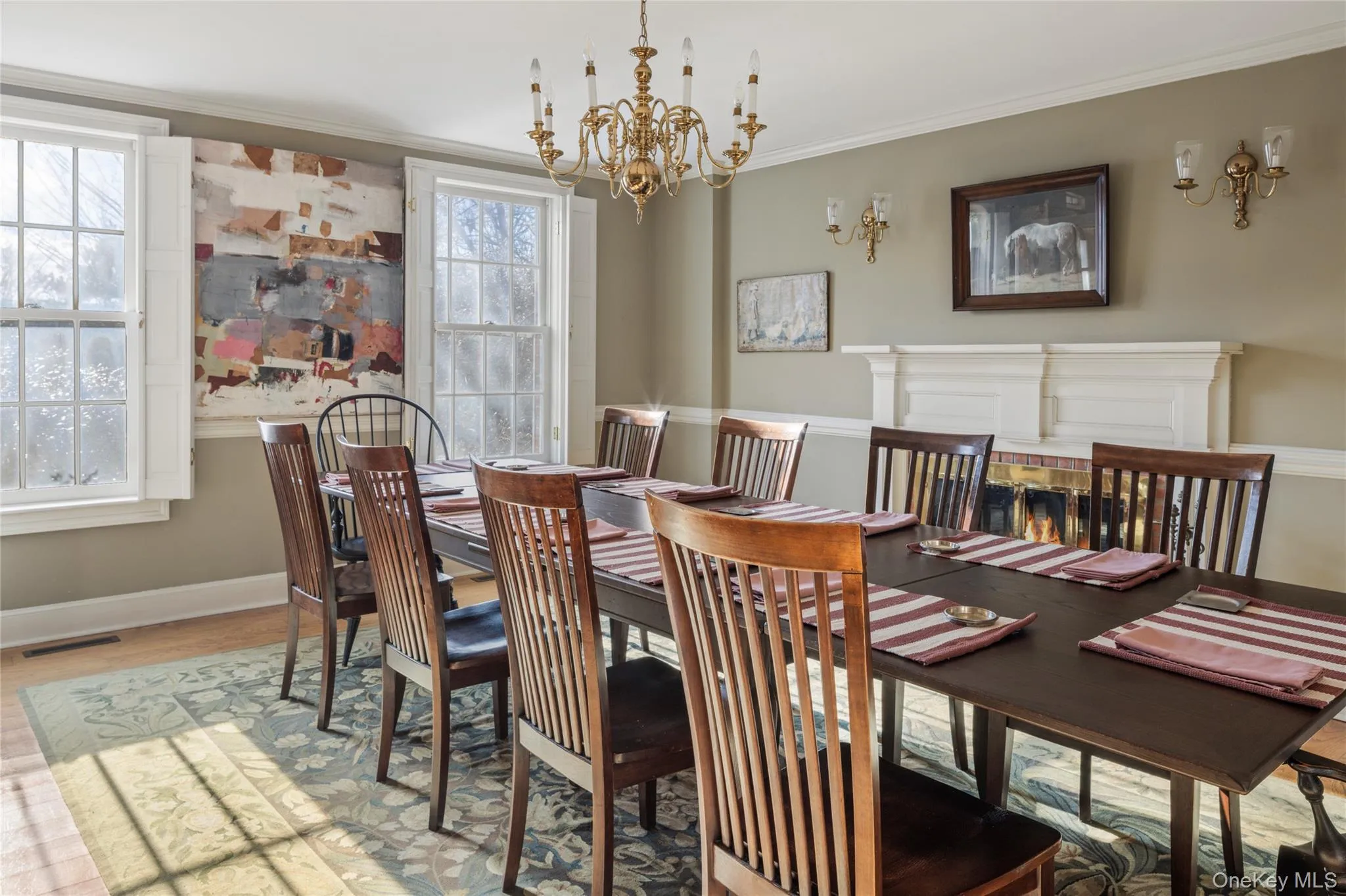 Dining space with visible vents, baseboards, a chandelier, wood finished floors, and ornamental molding Dining space with visible vents, baseboards, a chandelier, wood finished floors, and ornamental molding