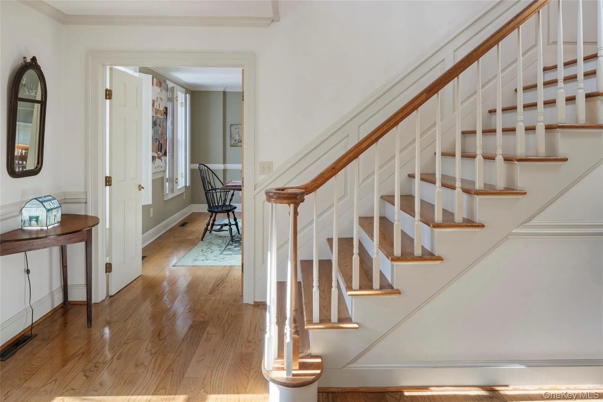 Stairway with ornamental molding, wood finished floors, and visible vents Stairway with ornamental molding, wood finished floors, and visible vents