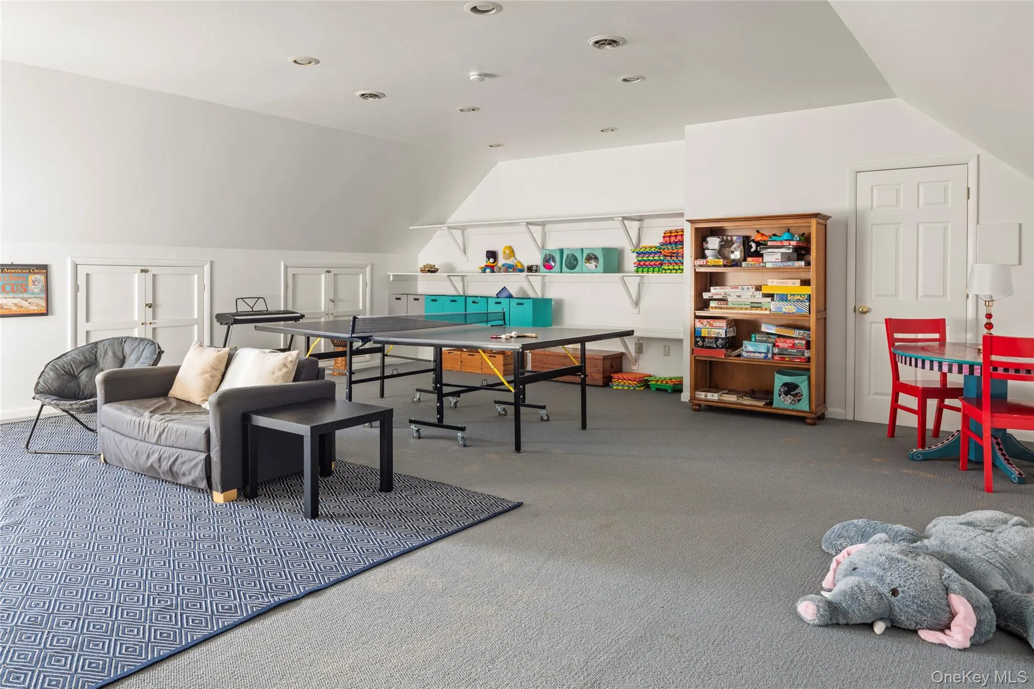Recreation room with vaulted ceiling, visible vents, and carpet Recreation room with vaulted ceiling, visible vents, and carpet