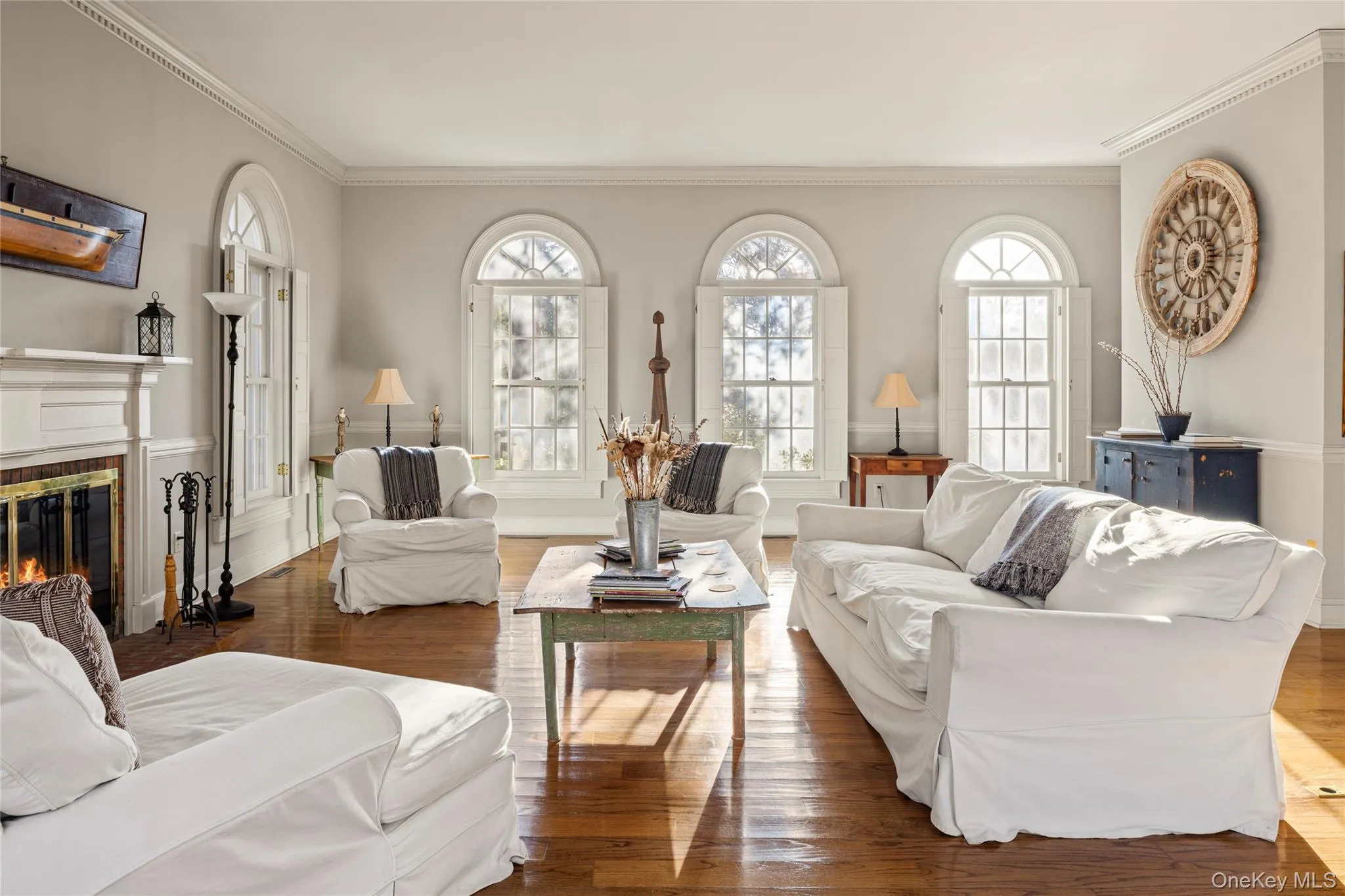 Living room featuring a glass covered fireplace, wood finished floors, and ornamental molding Living room featuring a glass covered fireplace, wood finished floors, and ornamental molding