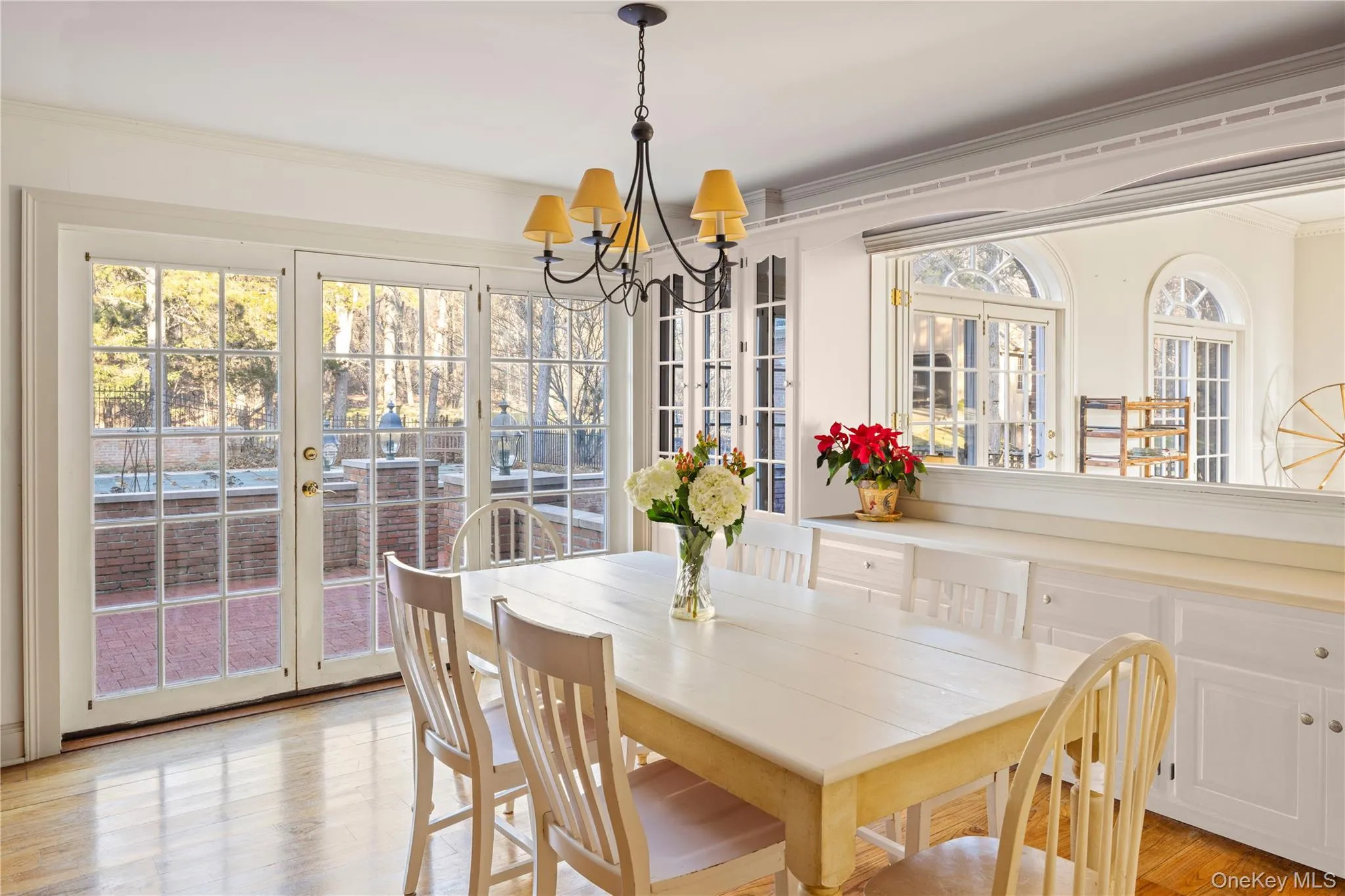Dining room featuring a chandelier, plenty of natural light, light wood-type flooring, and ornamental molding Dining room featuring a chandelier, plenty of natural light, light wood-type flooring, and ornamental molding