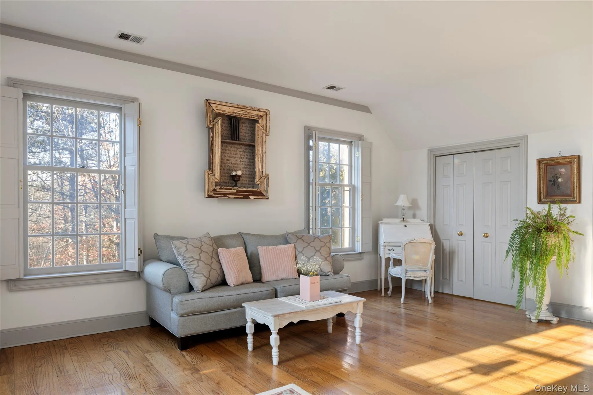 Living area featuring wood finished floors, visible vents, and baseboards Living area featuring wood finished floors, visible vents, and baseboards