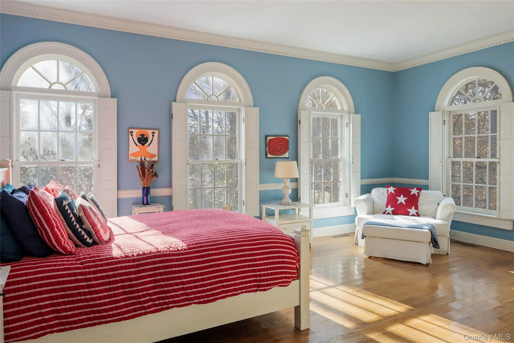 Bedroom with baseboards, wood finished floors, ornamental molding, and multiple windows Bedroom with baseboards, wood finished floors, ornamental molding, and multiple windows