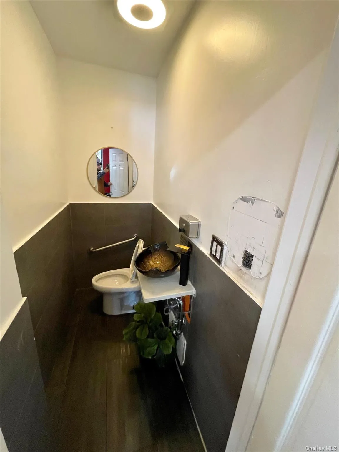 Half bathroom with wood finished floors and a wainscoted wall Half bathroom with wood finished floors and a wainscoted wall