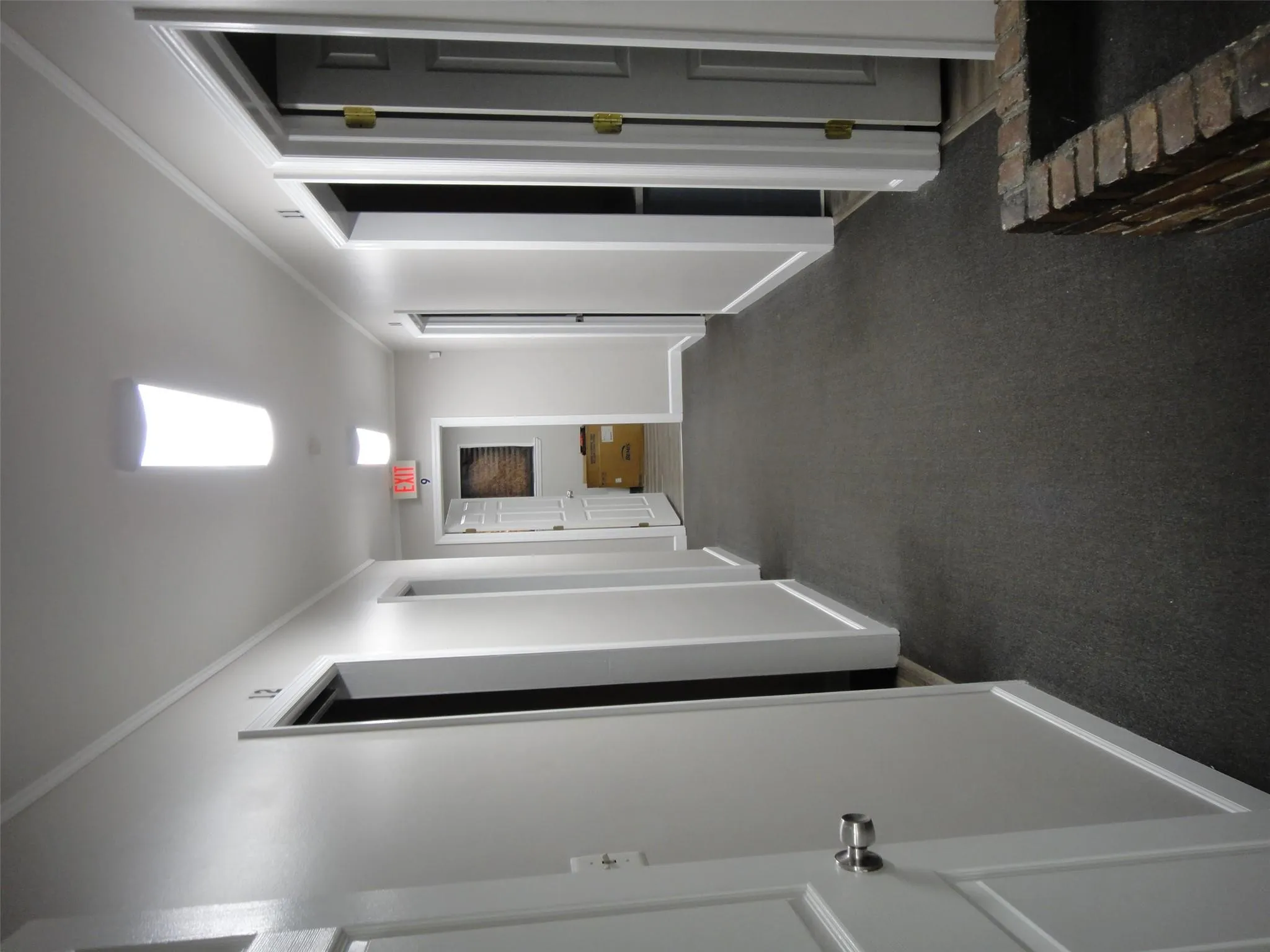 Hall with crown molding, baseboards, and dark colored carpet Hall with crown molding, baseboards, and dark colored carpet