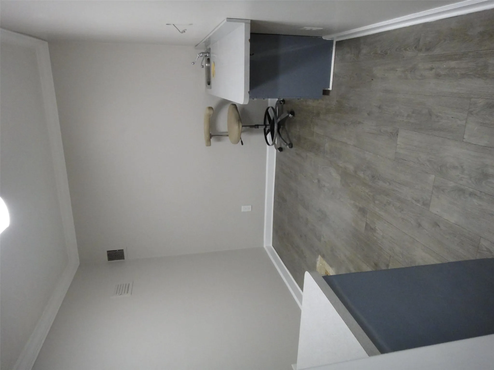 Unfurnished office featuring dark wood finished floors, crown molding, a sink, and baseboards Unfurnished office featuring dark wood finished floors, crown molding, a sink, and baseboards