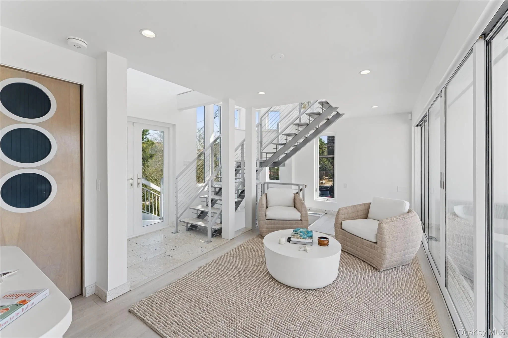 Sitting room featuring baseboards, recessed lighting, stairway, and a healthy amount of sunlight Sitting room featuring baseboards, recessed lighting, stairway, and a healthy amount of sunlight