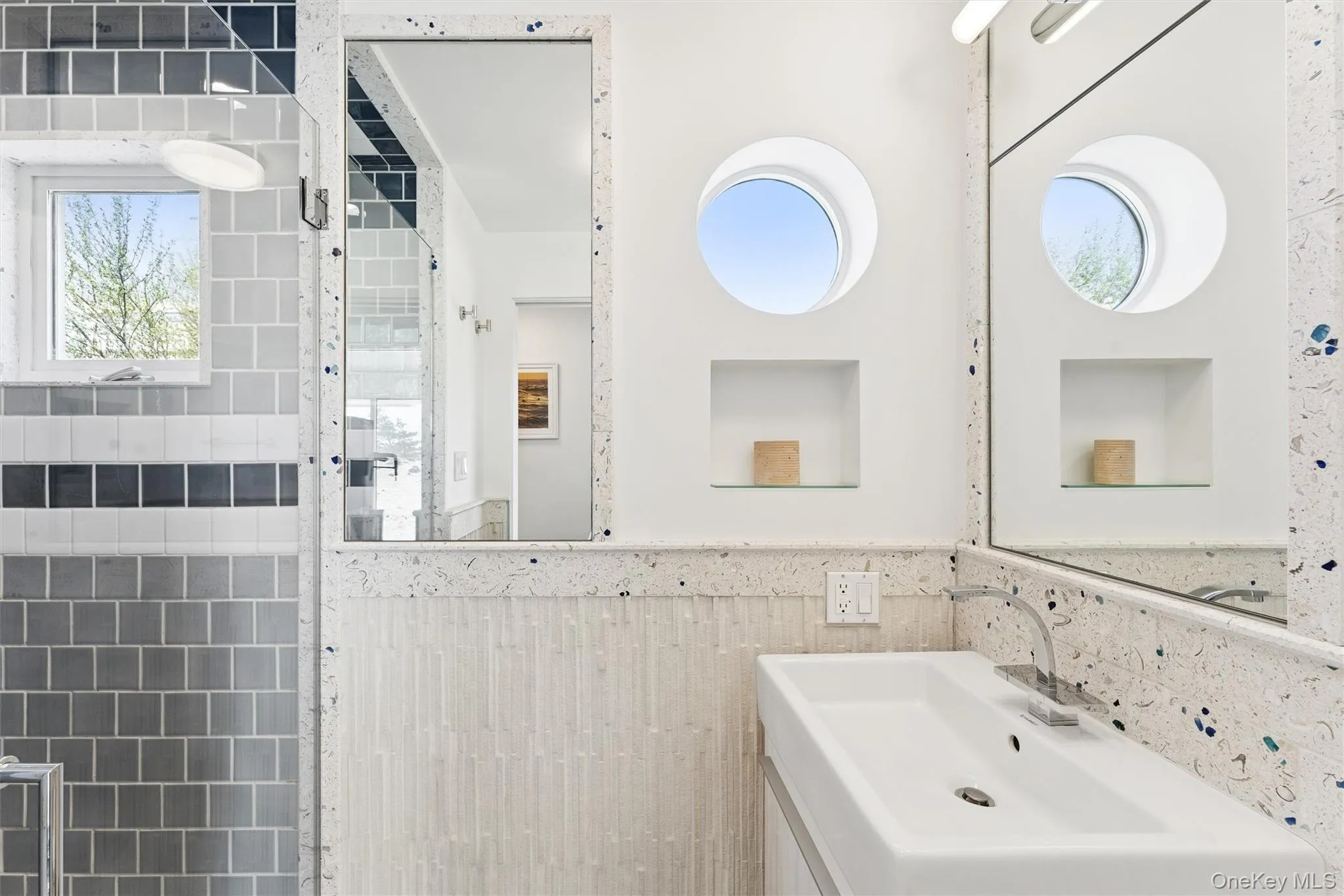 Bathroom featuring a sink, wainscoting, and tile walls Bathroom featuring a sink, wainscoting, and tile walls