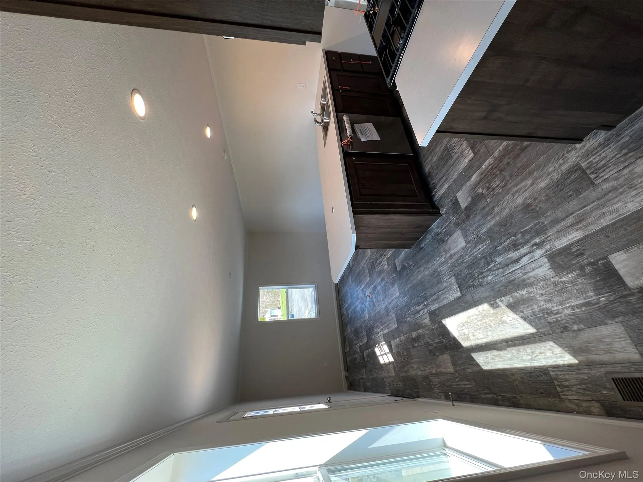 Kitchen with light countertops, visible vents, dishwashing machine, and dark wood-type flooring Kitchen with light countertops, visible vents, dishwashing machine, and dark wood-type flooring