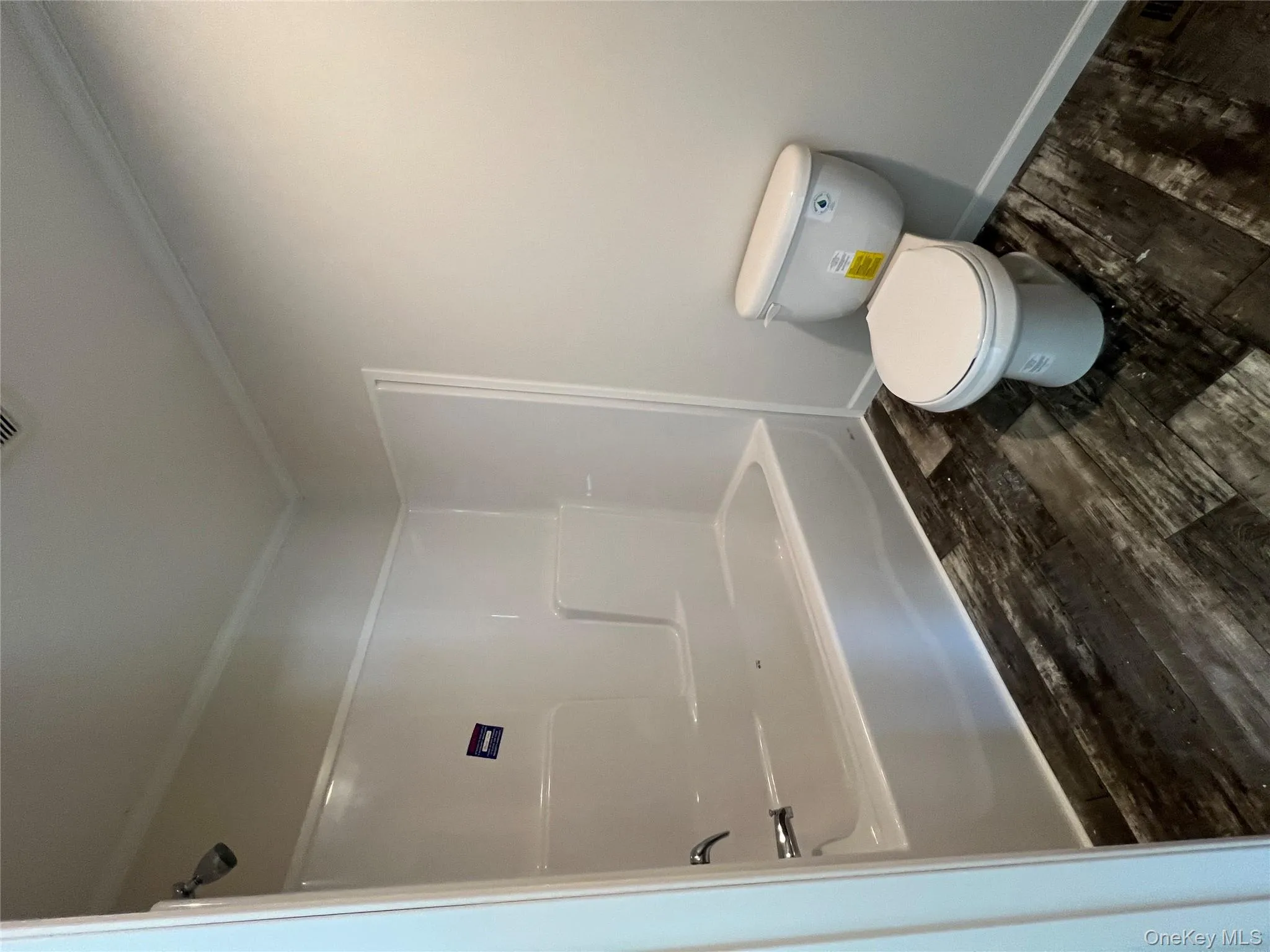 Full bath with toilet, crown molding, bathtub / shower combination, baseboards, and wood finished floors Full bath with toilet, crown molding, bathtub / shower combination, baseboards, and wood finished floors