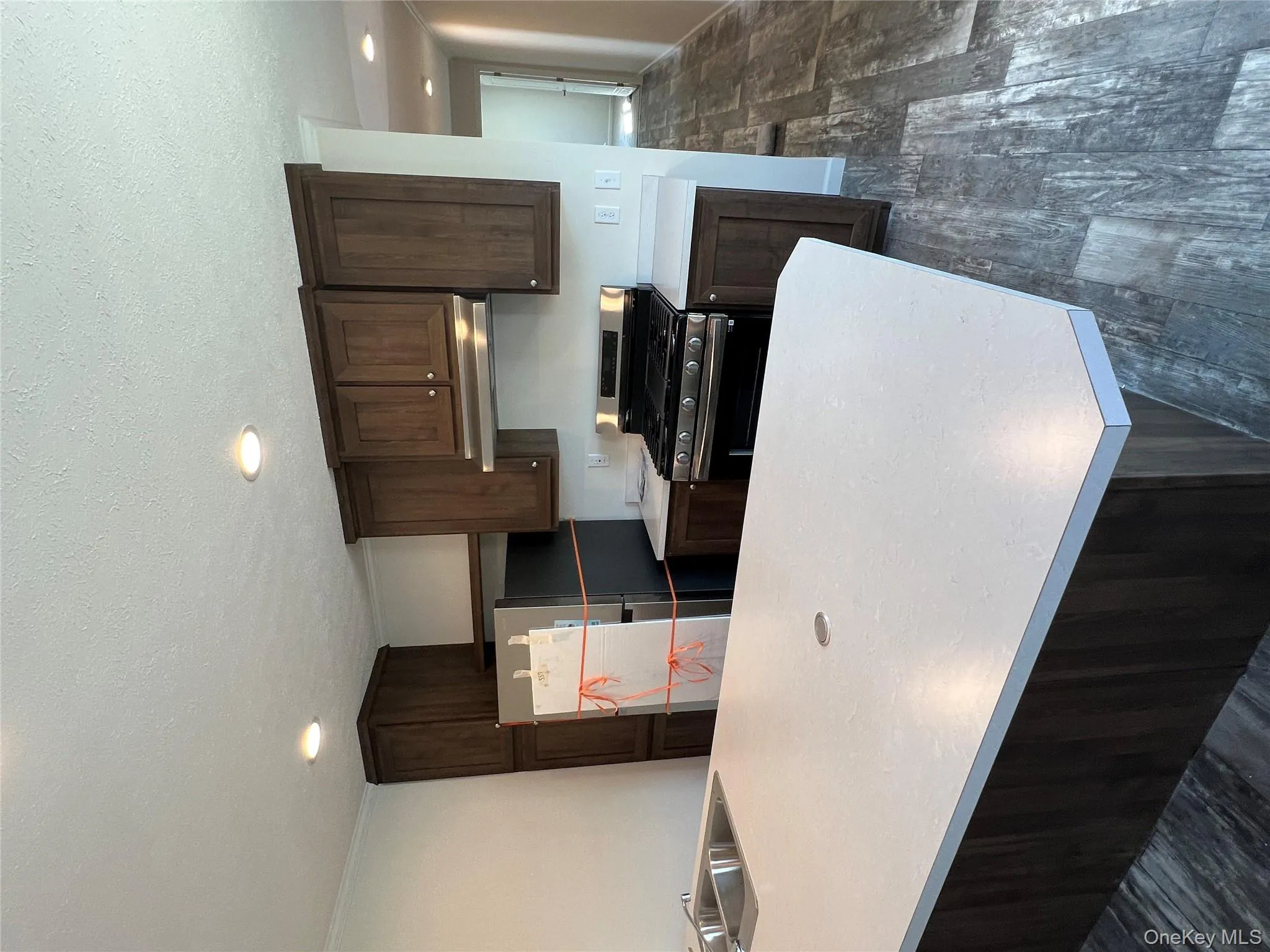 Kitchen with gas stove, dark brown cabinetry, fridge, a sink, and ventilation hood Kitchen with gas stove, dark brown cabinetry, fridge, a sink, and ventilation hood