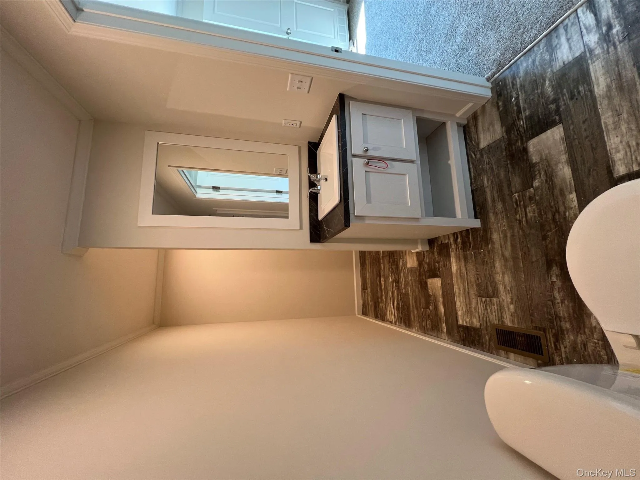 Half bath with visible vents, wood finished floors, vanity, and ornamental molding Half bath with visible vents, wood finished floors, vanity, and ornamental molding