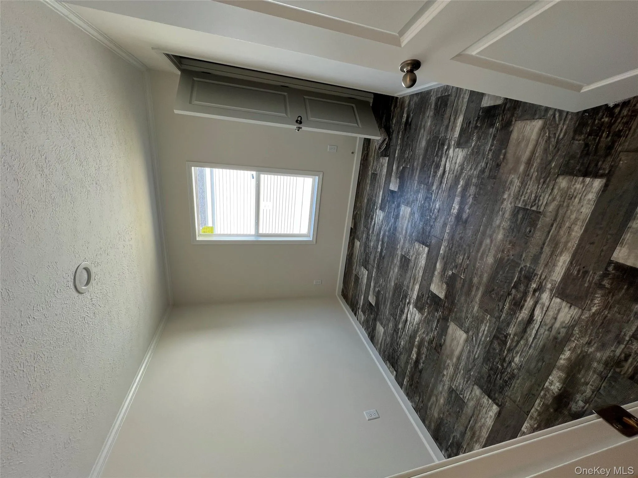 Unfurnished room featuring dark wood-style floors, baseboards, a textured ceiling, and crown molding Unfurnished room featuring dark wood-style floors, baseboards, a textured ceiling, and crown molding