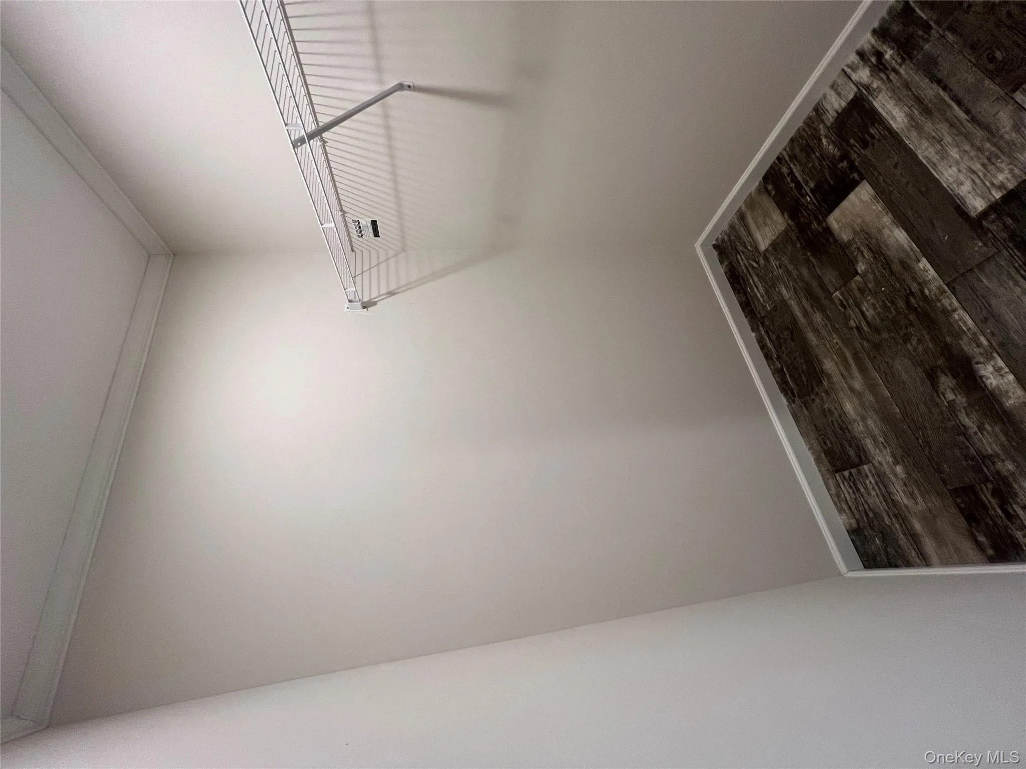 Walk in closet featuring dark wood finished floors Walk in closet featuring dark wood finished floors