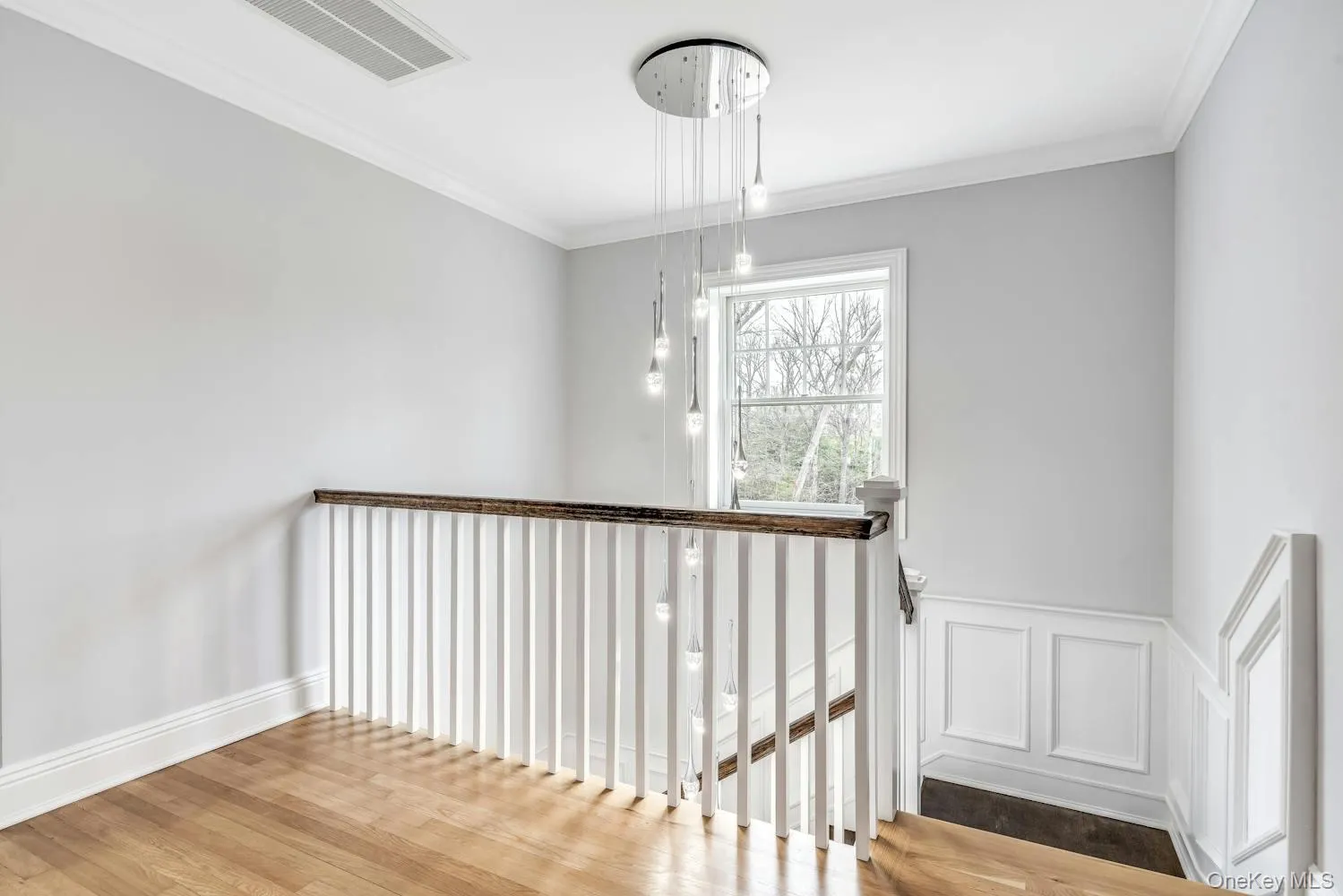 Stairs featuring crown molding, baseboards, visible vents, and wood finished floors Stairs featuring crown molding, baseboards, visible vents, and wood finished floors