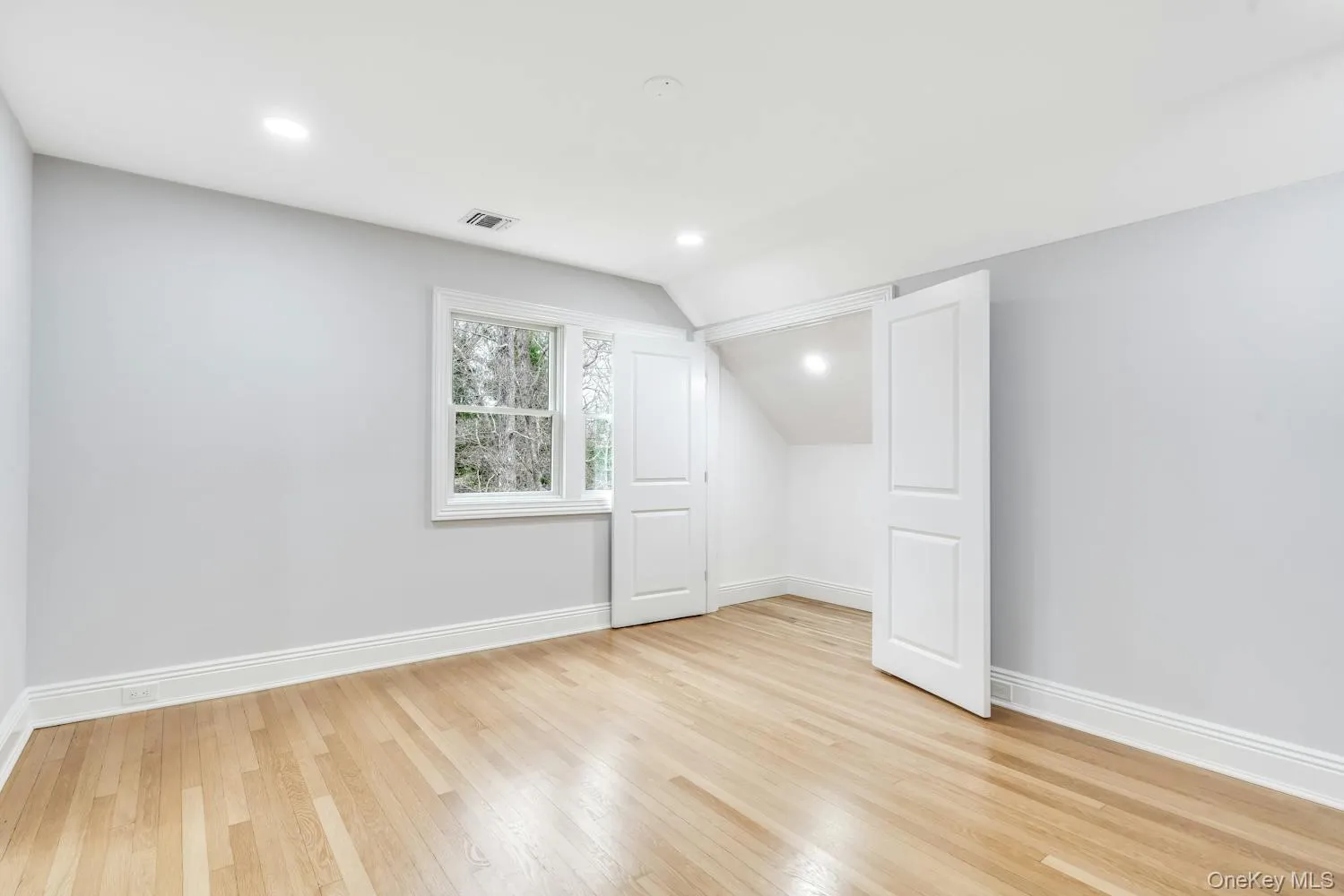Bonus room featuring baseboards, visible vents, light wood-style flooring, and lofted ceiling Bonus room featuring baseboards, visible vents, light wood-style flooring, and lofted ceiling