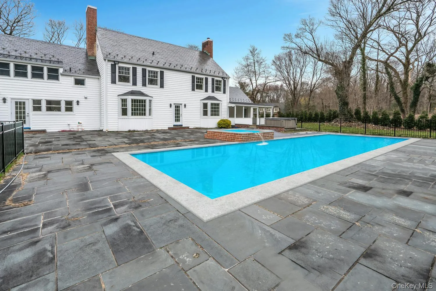 View of swimming pool featuring a fenced in pool, fence, a hot tub, and a patio area View of swimming pool featuring a fenced in pool, fence, a hot tub, and a patio area