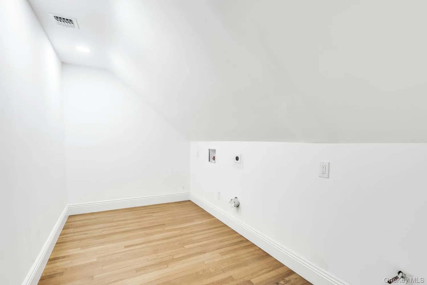 Additional living space featuring baseboards, vaulted ceiling, light wood finished floors, and visible vents Additional living space featuring baseboards, vaulted ceiling, light wood finished floors, and visible vents