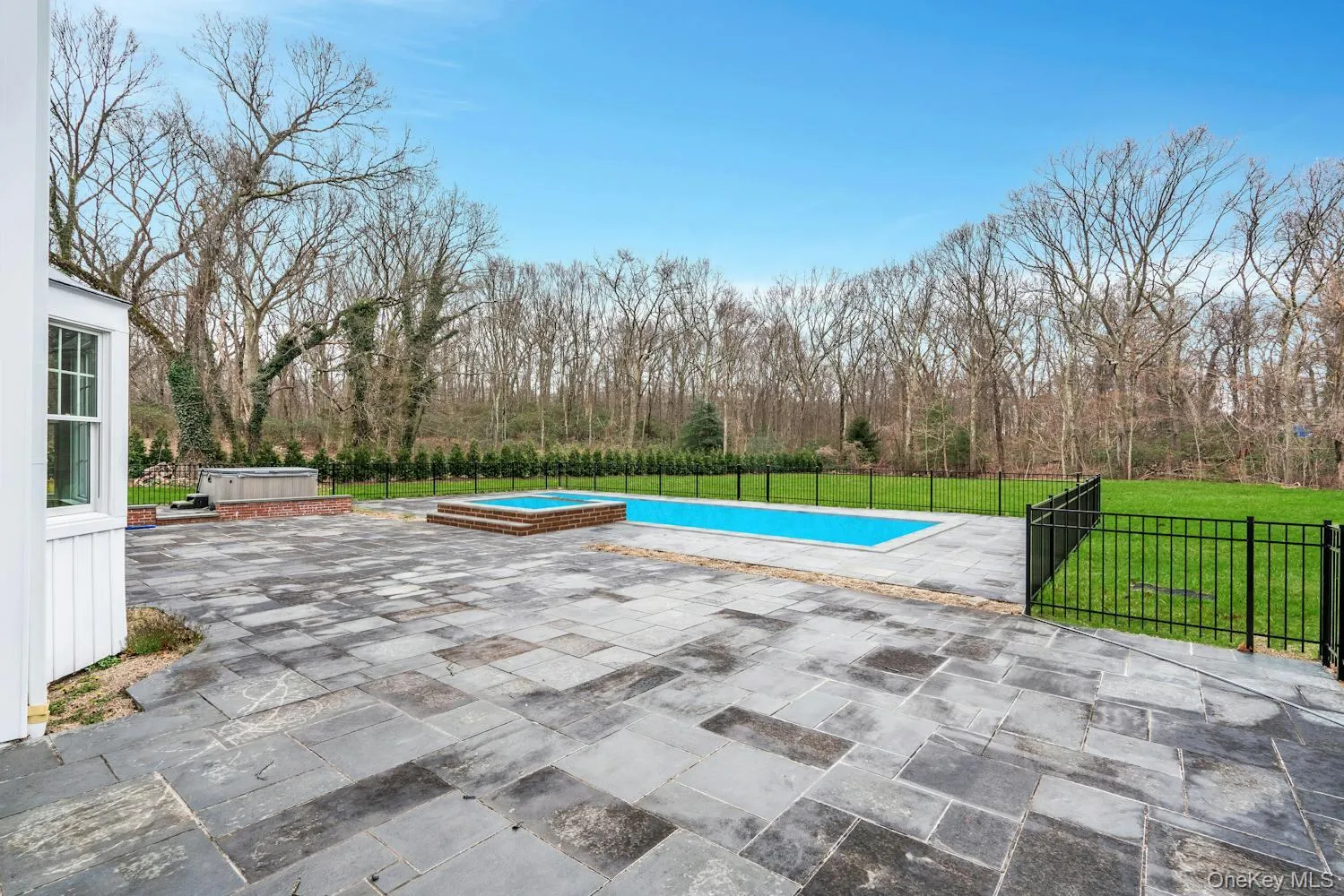 View of pool with a hot tub, a lawn, fence, and a patio View of pool with a hot tub, a lawn, fence, and a patio