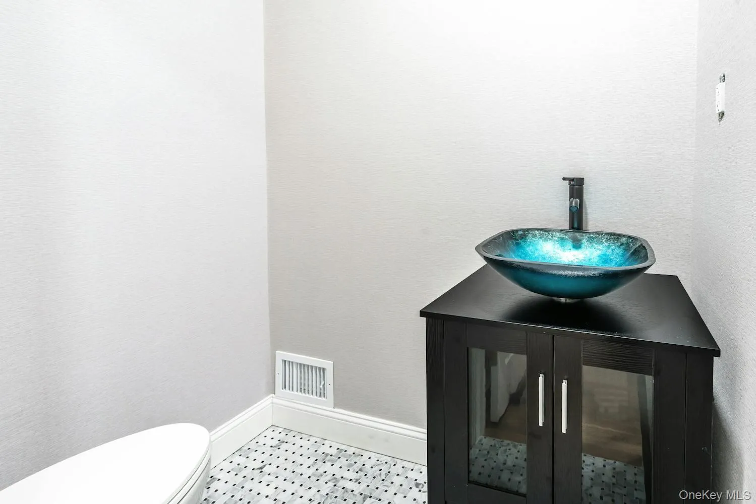 Half bath featuring toilet, baseboards, visible vents, and a sink Half bath featuring toilet, baseboards, visible vents, and a sink