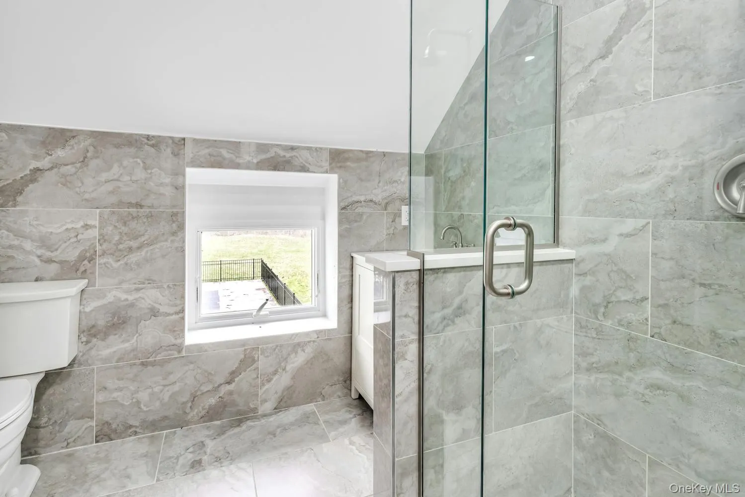 Full bath featuring toilet and a shower stall Full bath featuring toilet and a shower stall